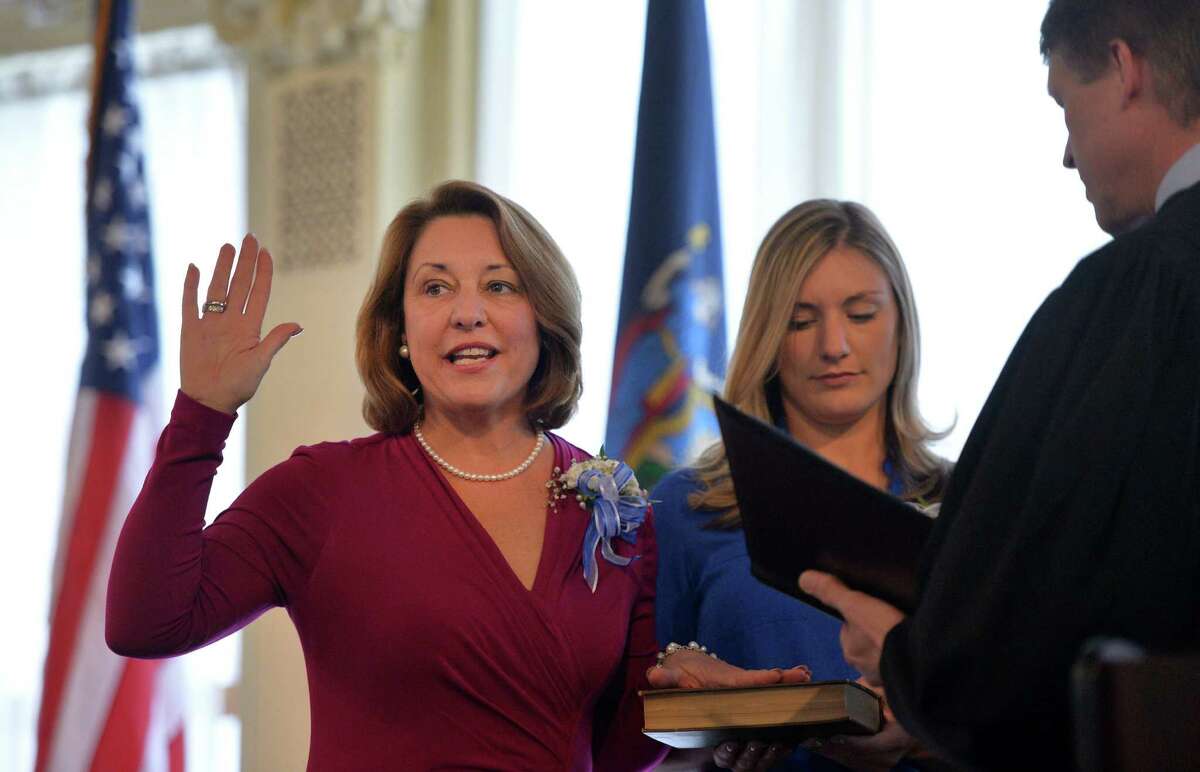 Saratoga Springs Mayor Joanne Yepsen is sworn in by Saratoga City Court Judge Jeffrey Wait, right, Wednesday afternoon Jan. 1, 2014 in the Canfield Casino in Saratoga Springs, N.Y. Holding the Bible is her daughter Emma. (Skip Dickstein / Times Union)