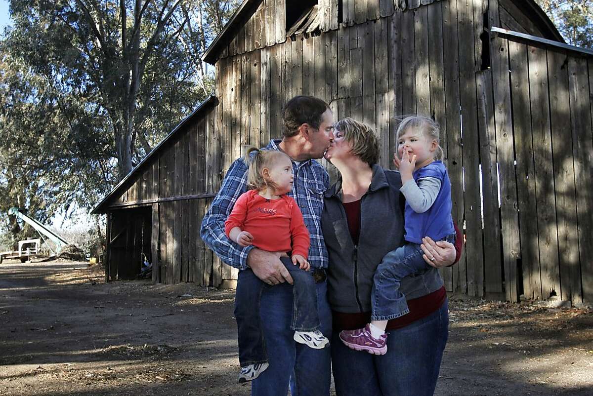 Rebekah and Ken Sullivan pictured with their daughters Ruth, 1, left, and Grace, 3, outside of the oldest barn on their property December 20, 2013 at their home and Almond orchard in Orland, Calif. Ken Sullivan is a fourth generation Almond farmer, the land has been in his family for 100 years. Rebekah always knew she wanted to be a stay-at-home mother and had dreamt of ending up with a farmer. The two have been married for a little over four years now and they have two daughters. Both of them say they feel blessed to have found each other through the dating website, Farmer's Only.