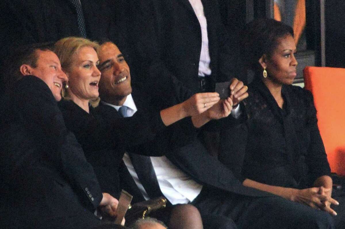 President Barack Obama (right) and British Prime Minister David Cameron pose for a selfie picture with Denmark's Prime Minister Helle Thorning Schmidt (center) next to first lady Michelle Obama  during the memorial service of South African former president Nelson Mandela.
