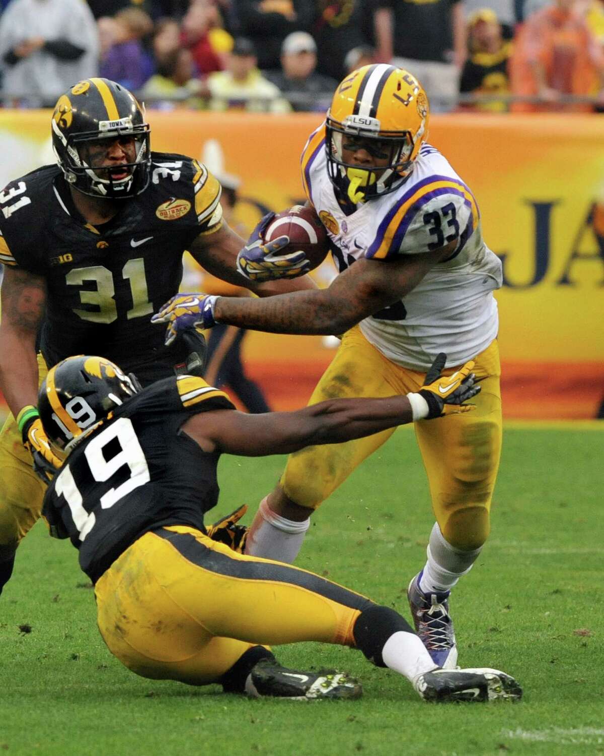 LSU's Jeremy Hill brushes aside Iowa's B.J. Lowery (19) while picking up a portion of his 216 yards.