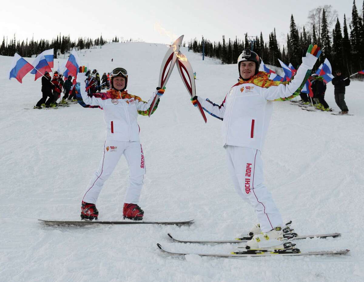 Torch bearers in the Sheregesh winter sports resort in western Siberia hold Olympic torches en route for the Winter Olympics in the Russian Black Sea resort of Sochi. The Games run Feb. 7-23.