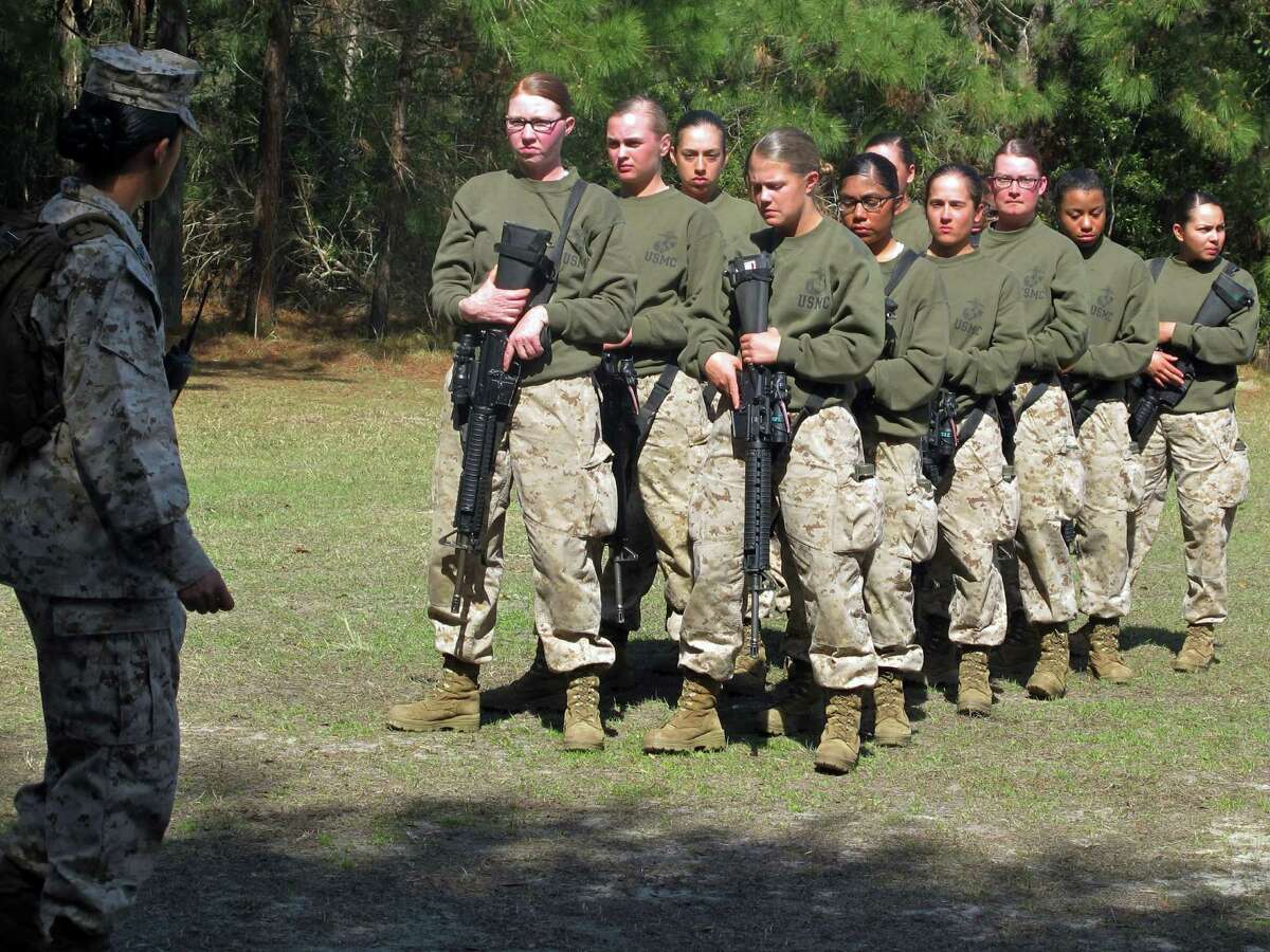 FILE - This Feb. 21, 2013 file photo shows female recruits at the Marine Corps Training Depot on Parris Island, S.C. More than half of female Marines in boot camp can't do three pull-ups, the minimum standard that was supposed to take effect with the new year. So the Corps is delaying the requirement. All the service branches are working on devising standards, training and other policies needed to open thousands of combat roles to women in 2016. (AP Photo/Bruce Smith, File)