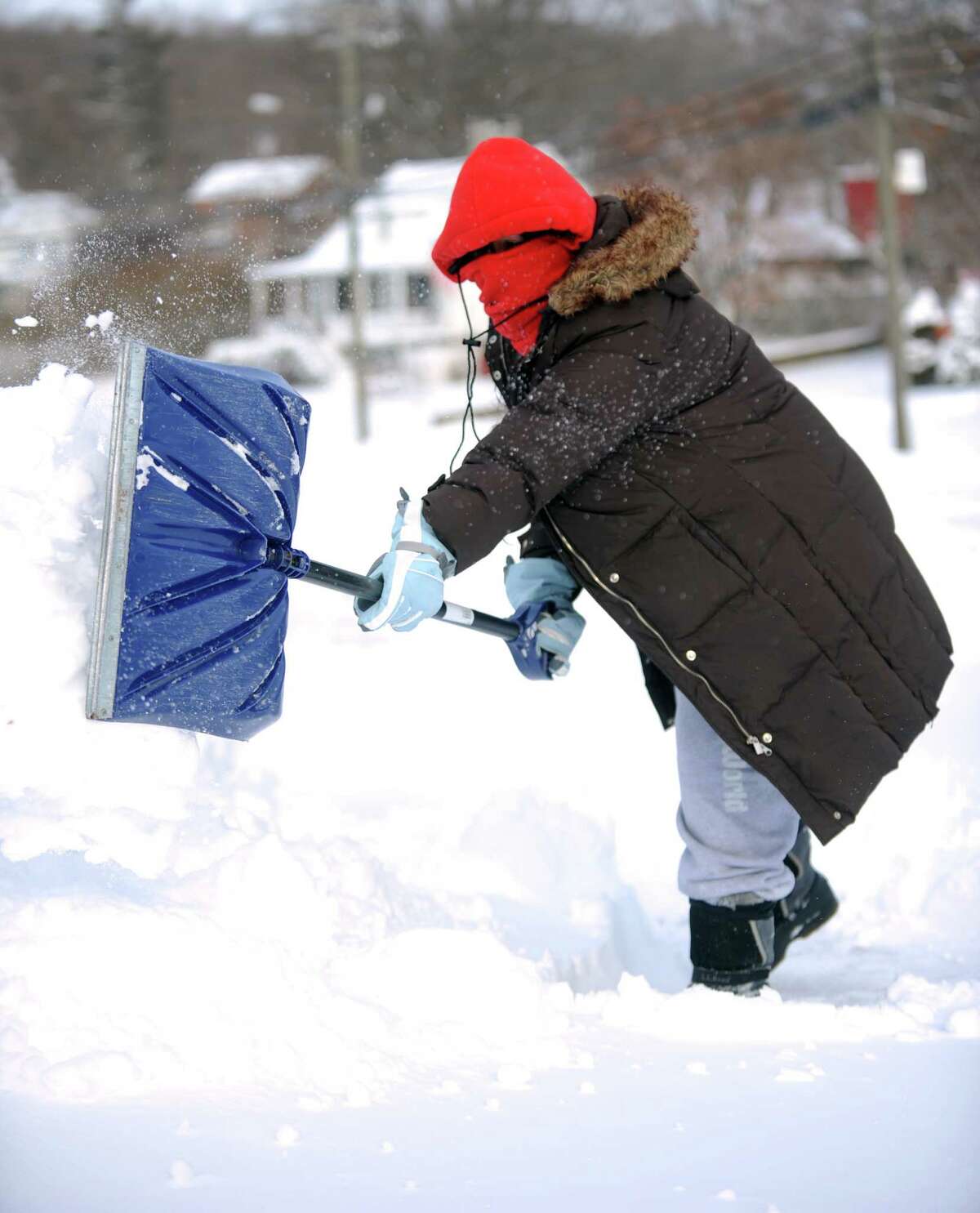 Michelle Reyes shovels a neighbor's sidewalk in Derby, Conn. Friday, Jan. 3, 2014.