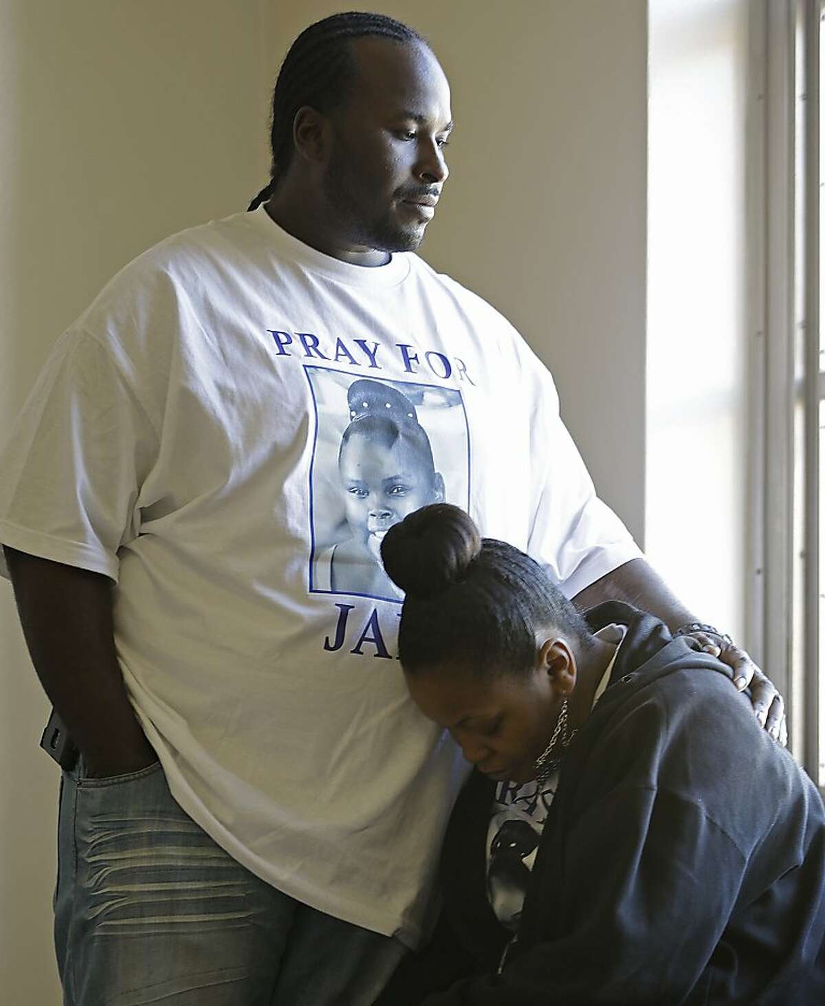 Marvin Winkfield places his arm around his wife Nailah Winkfield, mother of 13-year-old Jahi McMath, as they wait outside a courtroom Friday, Jan. 3, 2014, in Oakland, Calif. A federal magistrate was expected to meet Friday with lawyers to try to resolve a dispute over the care ofJahi McMath, who was declared brain dead after tonsil surgery. (AP Photo/Ben Margot)