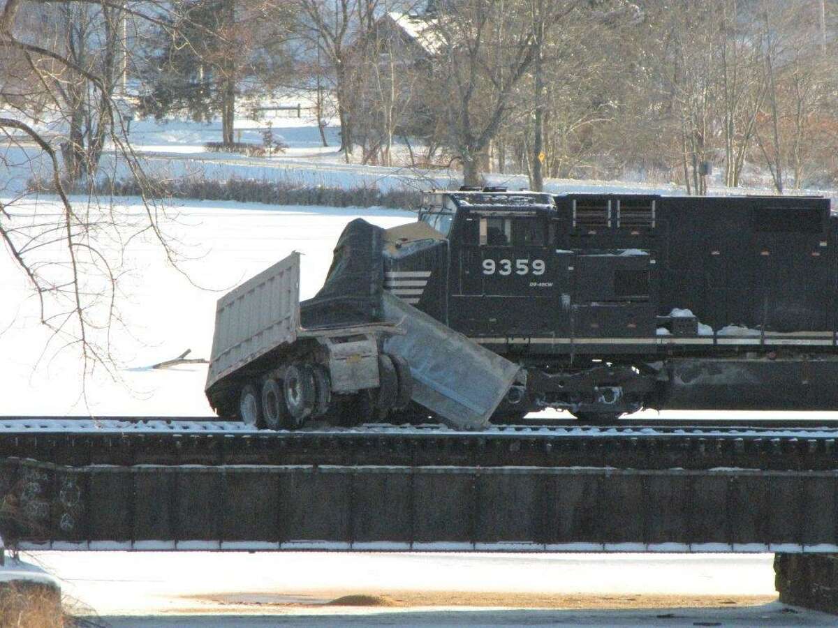 Trucker survives train crash, river