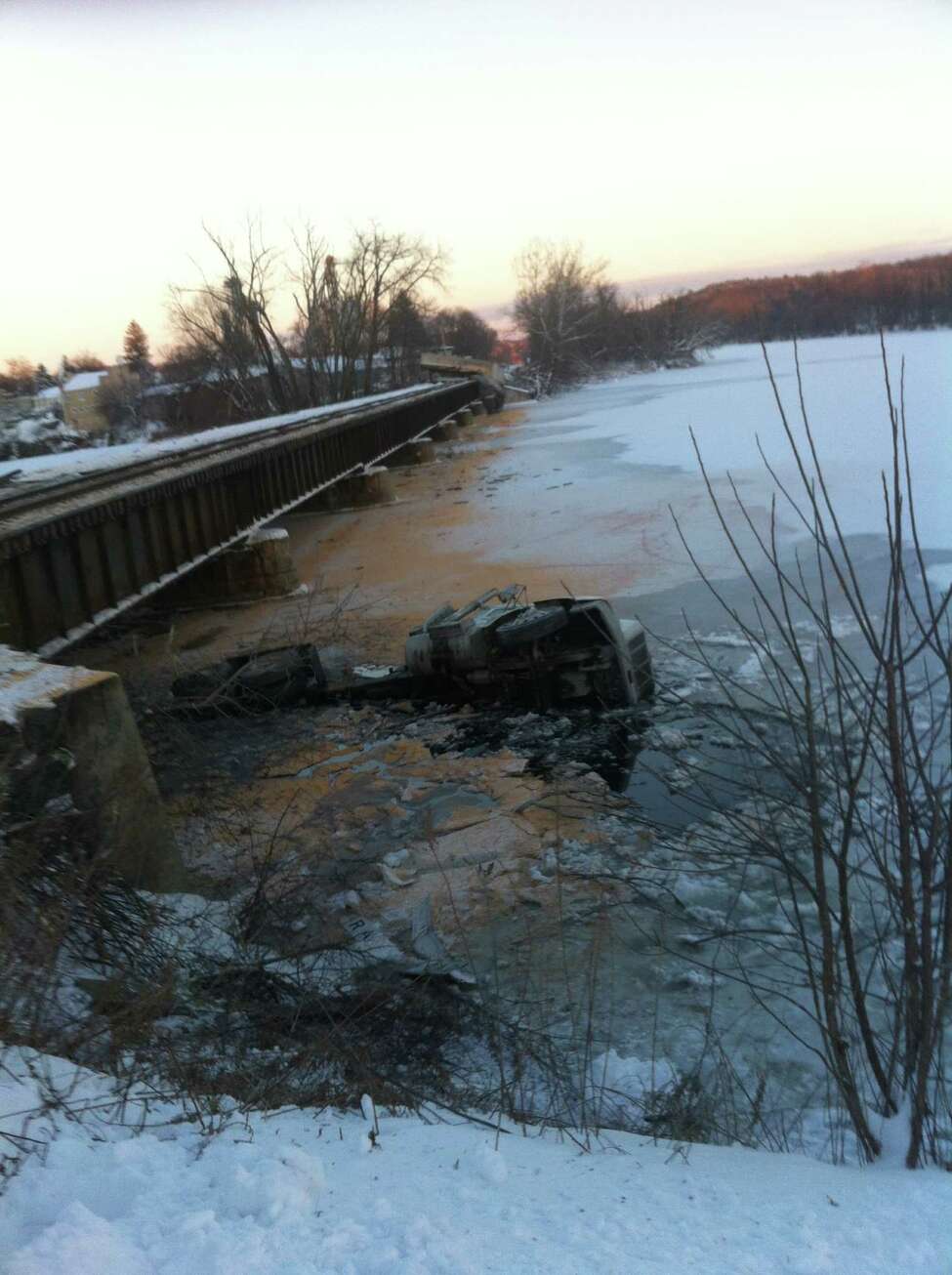 Trucker survives train crash, river