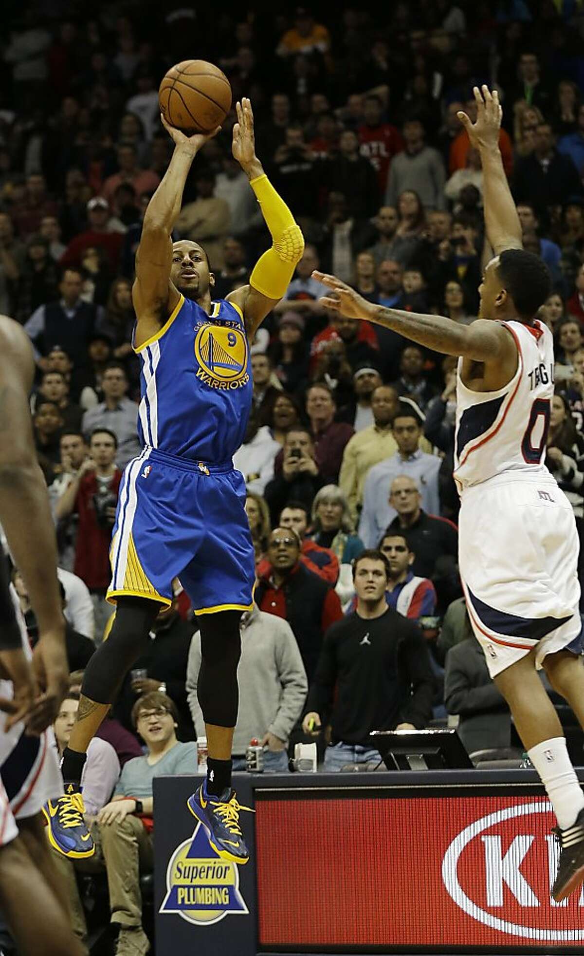 Golden State Warriors small forward Andre Iguodala (9) hits a three-point basket to give the Warriors a 101-100 win over the Atlanta Hawks as time expires in the second half of an NBA basketball game on Friday, Jan. 3, 2014, in Atlanta. Atlanta Hawks point guard Jeff Teague (0) defends. (AP Photo/John Bazemore)