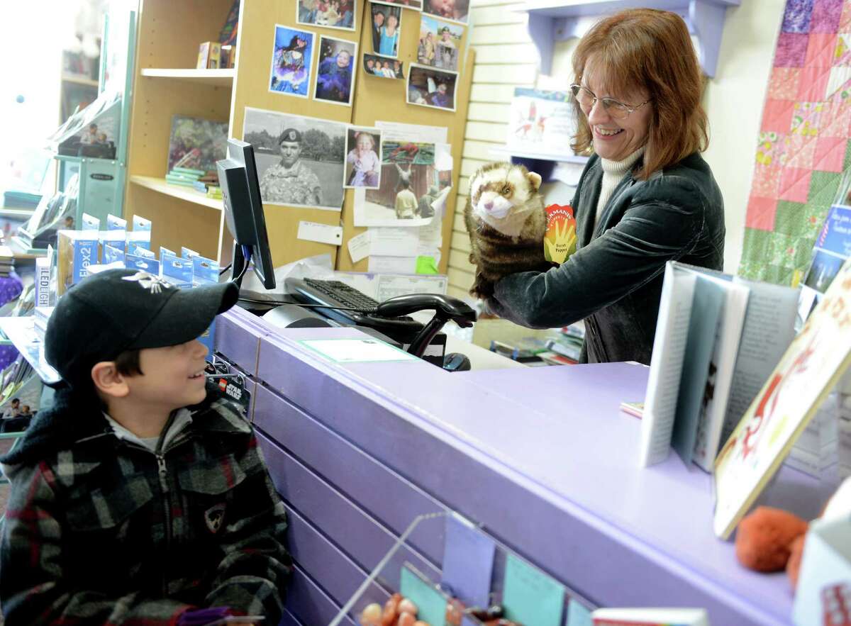 Linda Devlin shows customer Trey Migliarese, 8, of Monroe, how to animate his new stuffed puppet Saturday, Jan. 4, 2013 at her book store, Linda's Story Time in Monroe, Conn.