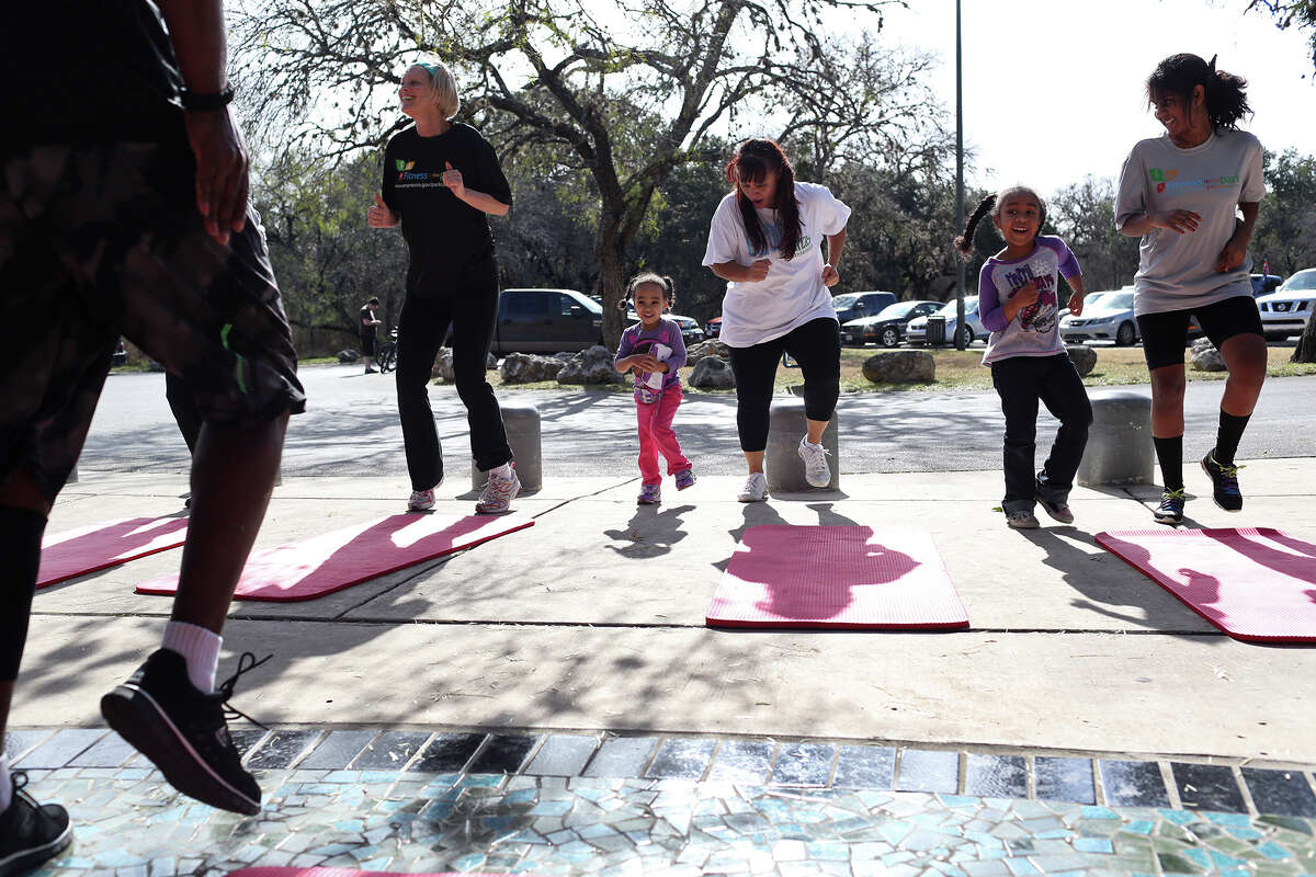 Michael Jones, far left, leads Elaine Stephens, from left, his niece, Melia Brown, 3, his wife, Gloria Jones, niece Semaya Brown, 6, and his daughter, Jaedan Jones, 12, during a high intensity interval training class with Fitness in the Park at McAllister Park in San Antonio on Saturday, January 4, 2014.