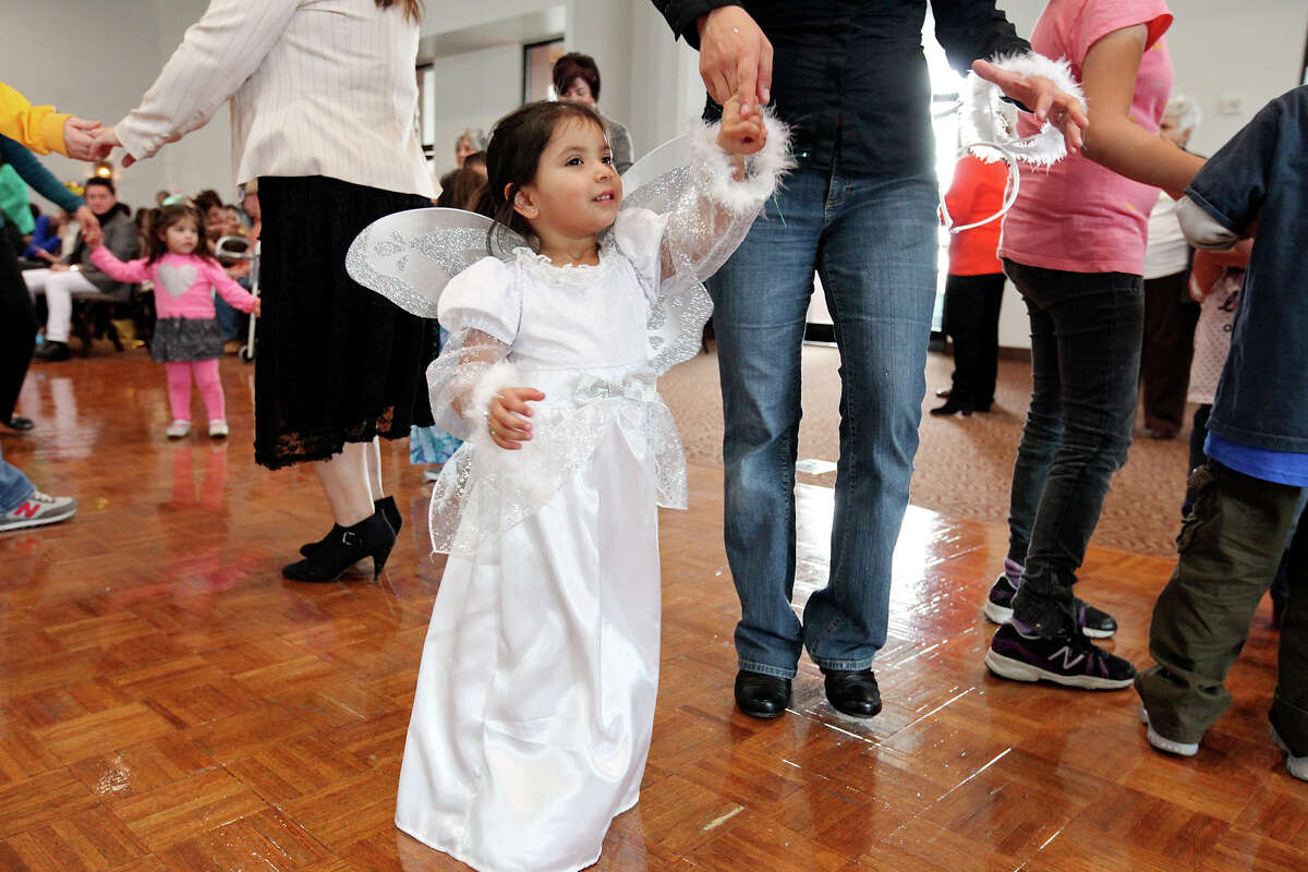 Wearing an angel costume Viviana Ramos, 2, dances with her mom Deborah Ramos during the Puerto Rican Heritage Society's Three Kings Day celebration held Sunday Jan. 5, 2014 at the AT&T Community Centre at San Fernando.