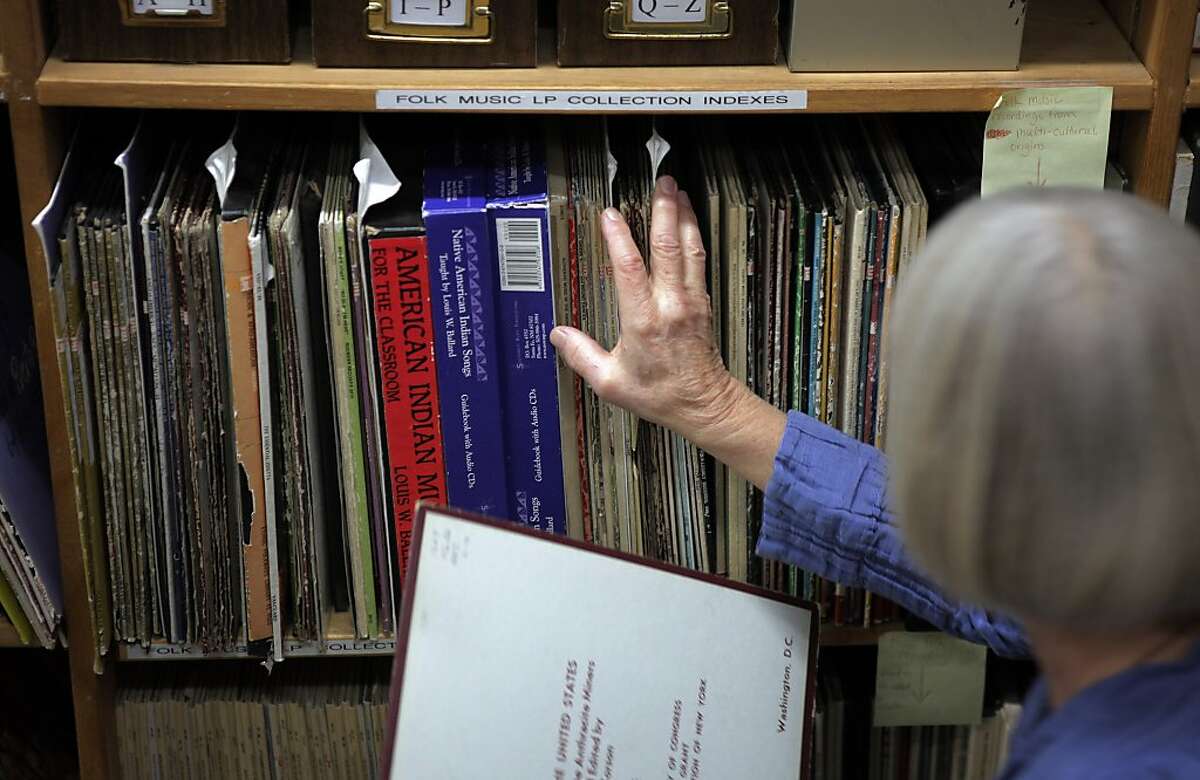 Anne Laskey, right, the Director of the Kodaly Center, returns a reference item to the shelves where the American Folk Song Collection is stored at Holy Names University on Monday, November 11, 2013, in Oakland, Calif. They have spent years working on an archive of American Folk music at Holy Names Univeristy and have begun an online version of their archive. A new grant would allow them to greatly expand the online archive's content.