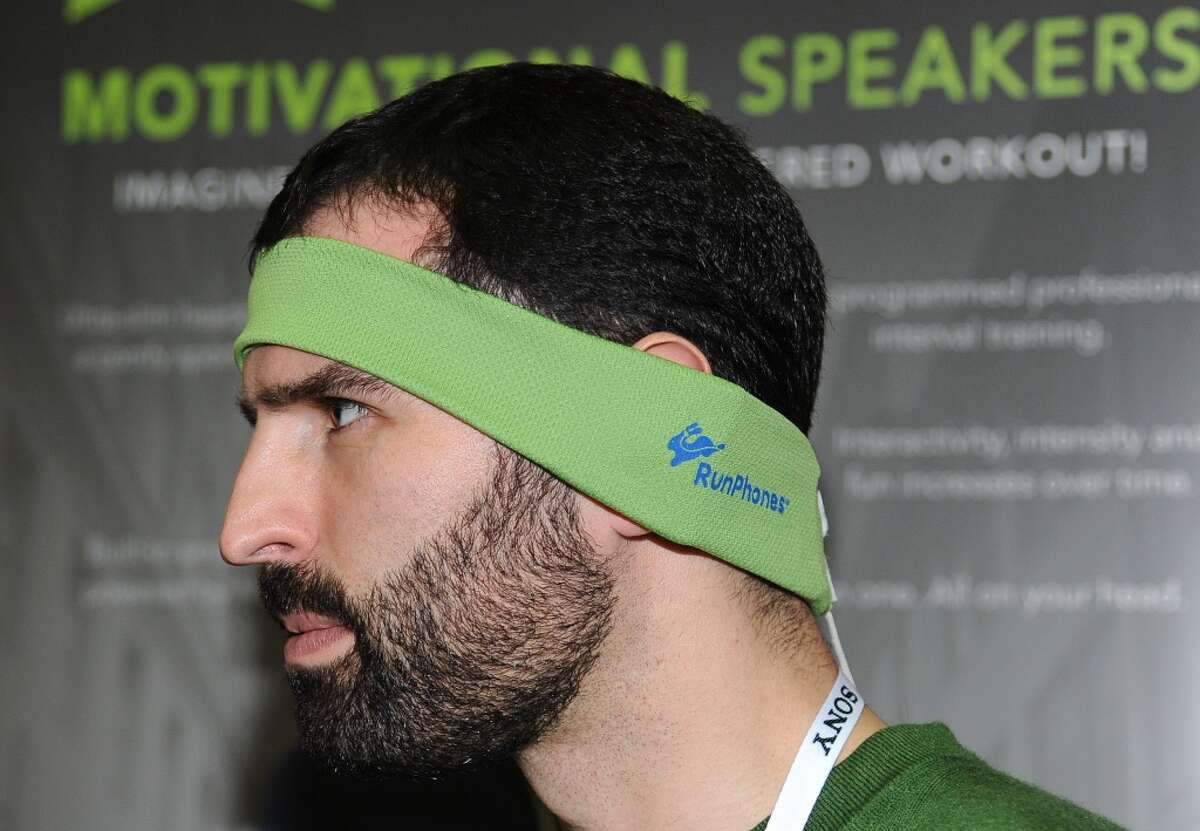 Casey Macioge representing AcousticSheep LLC wears a RunPhones headband, a moisture wicking headband with removable headphones at the "CES: Unveiled," media preview for International CES.