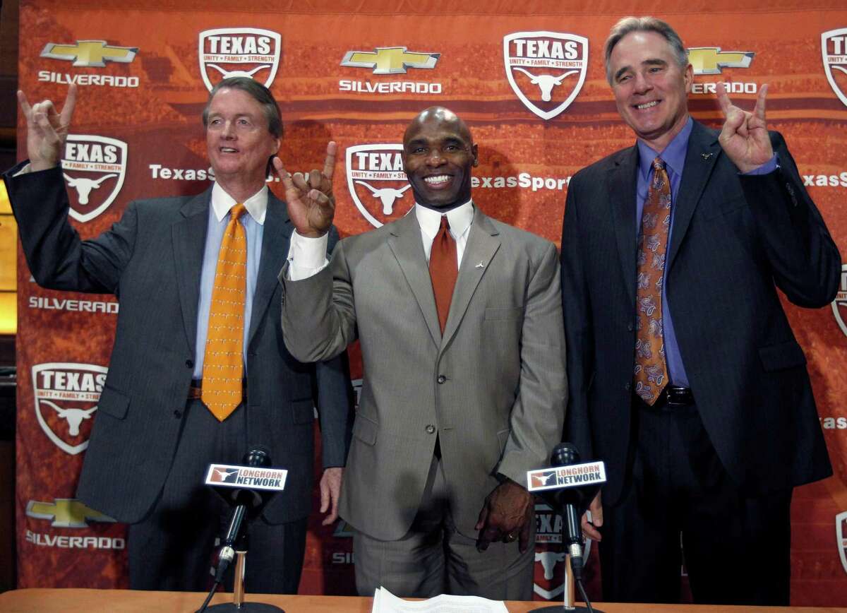 AUSTIN, TX - JANUARY 6: University of Texas president Bill Powers, left and athletic director Steve Patterson, right, introduce new Longhorns head football coach Charlie Strong from Louisville during a press conference January 6, 2014 at Darrell K. Royal-Texas Memorial Stadium in Austin, Texas.