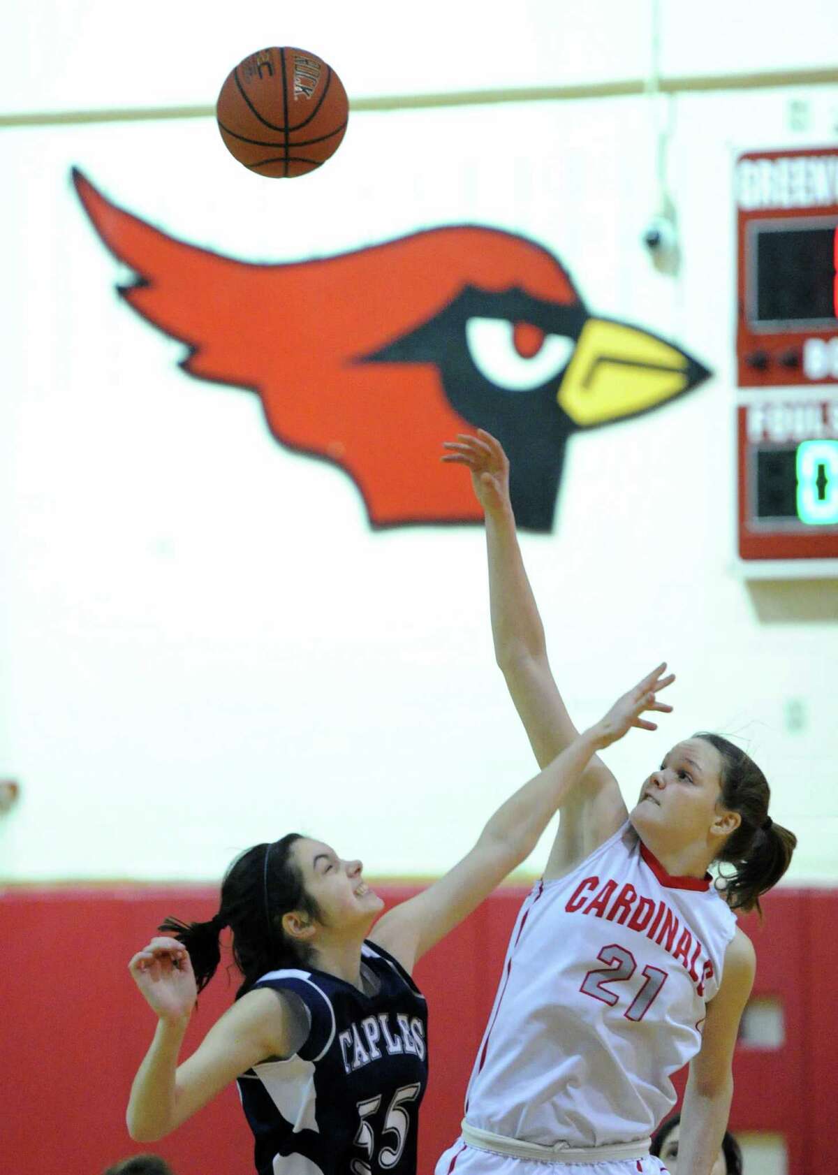 At left, Olivia Troy (# 55) of Staples jumps ball against Abby Wolf (# 21) of Greenwich during the girls high school basketball game between Greenwich High School and Staples High School at Greenwich, Tuesday, Jan. 7, 2014.
