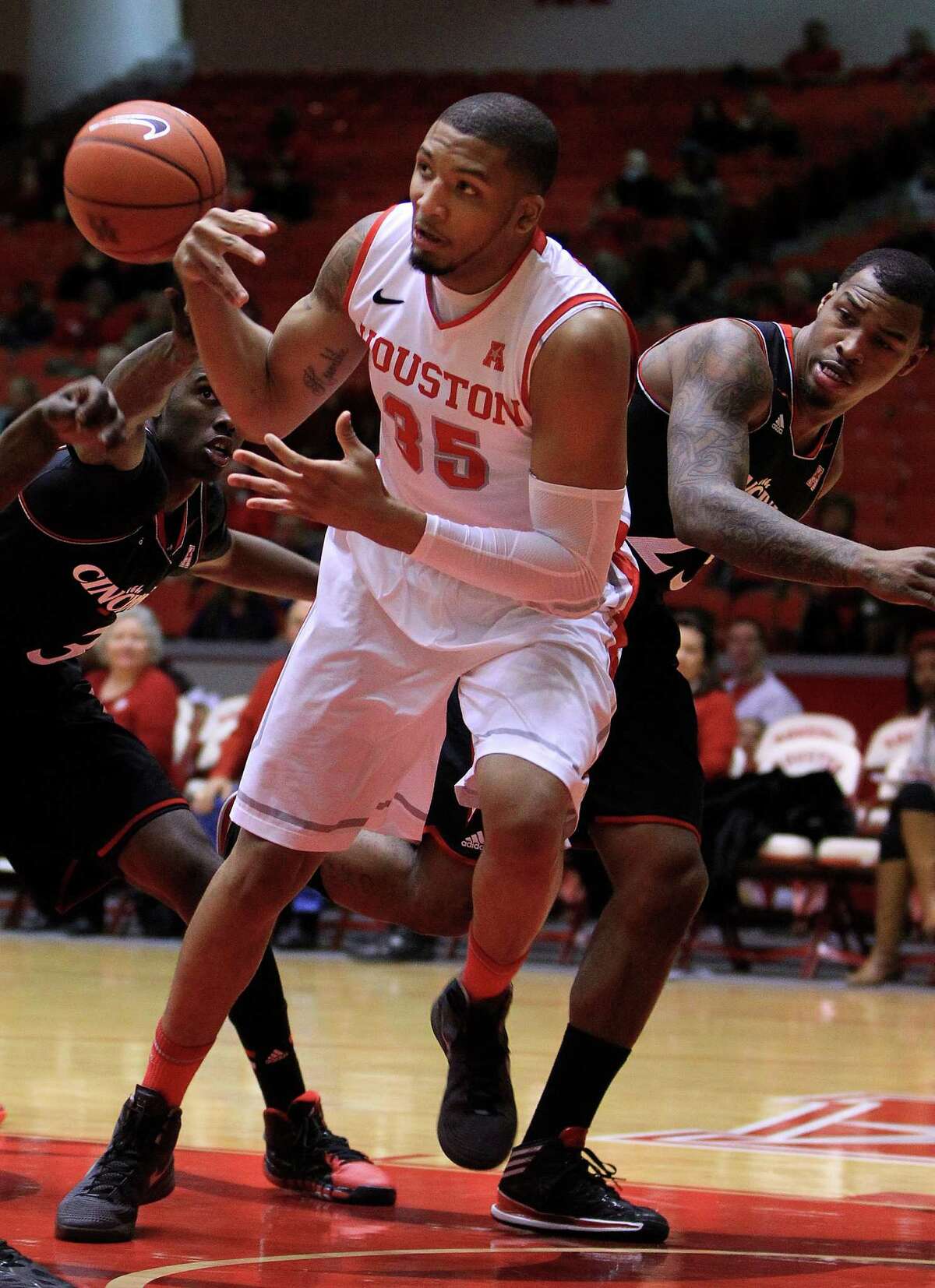 Houston Cougars forward TaShawn Thomas (35) gets the ball stripped from him by Cincinnati Bearcats forward Shaquille Thomas (3) and guard Sean Kilpatrick (23) during the first half of a college basketball game at Hofheinz Pavilion, Tuesday, Jan. 7, 2014, in Houston.