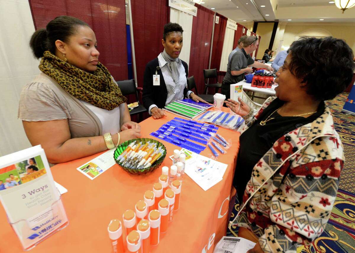 Job seeker Ivory Lewis, right speaks with representatives from Wellcare Health Plans, Tatiana Cunningham. left and Darlene Ross, center at the Times Union Job Fair Oct. 14, 2013 at the Marriott on Wolf Road in Colonie, N.Y. (Skip Dickstein/Times Union)