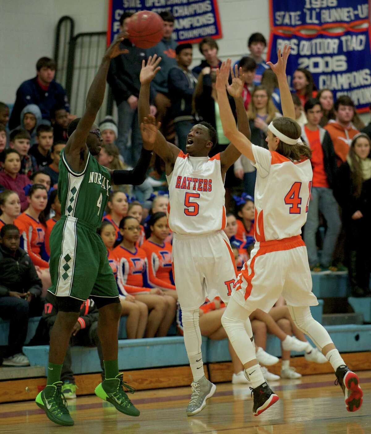 Norwalk's Roy Kane Jr (4) throws a pass over Danbury's C.J. White (5) and Mike Kline (41) during the boys FCIAC basketball game between Norwalk and Danbury high schools played at Danbury High School, Danbury, Conn, on Wednesday, January 8, 2014.