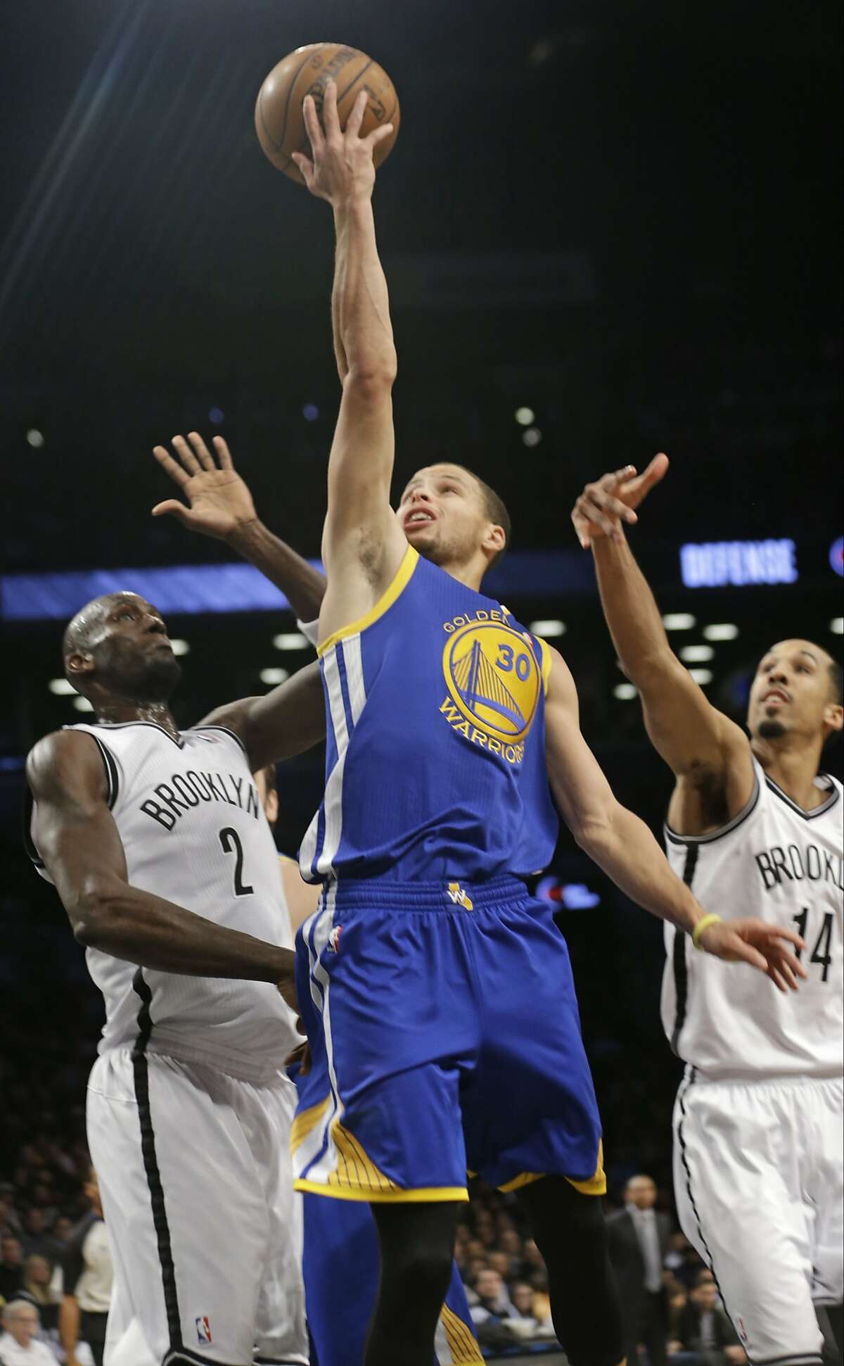 Golden State Warriors' Stephen Curry (30) drives past Brooklyn Nets' Kevin Garnett (2) and Shaun Livingston (14) during the first half of an NBA basketball game Wednesday, Jan. 8, 2014, in New York. The Nets won the game 102-98. (AP Photo/Frank Franklin II)