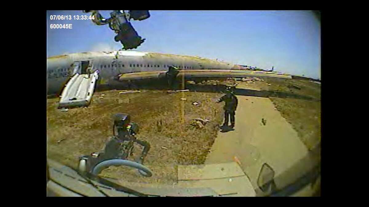 San Francisco firefighter Roger Phillips directs a fire rig around Ye Meng Yuan after the July 6,2013 crash of an Asiana Airlines jet at San Francisco International Airport. Firefighters had concluded that the 16-year-old Chinese girl was dead, although the San Mateo County coroner later said she was alive when the rig?•s dashboard camera filmed this image.