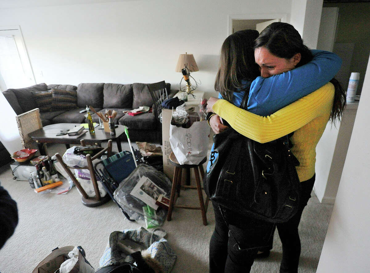 Kat Fairchild, right, hugs her neighbor, Nicole Bott, in Fairchild's apartment in Avalon Stamford Harbor in Stamford, Conn., on Thursday, Jan. 9, 2014. Last Saturday, a water line for the sprinkler system broke on the fourth floor above Fairchild's apartment on the second floor damaging her living space along with others.
