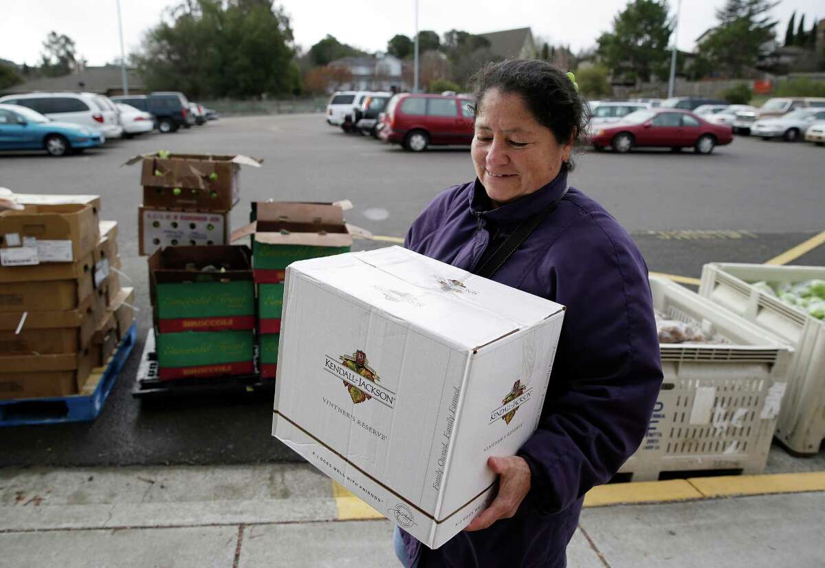 This photo taken Jan. 8, 2014 shows Maria Gonzalez carrying away her specially prepared box of food at a food bank distribution in Petaluma, Calif., part of a research project with Feeding America to try to improve the health of diabetics in food-insecure families. Doctors are warning that the federal government could be socked with a bigger health bill if Congress cuts food stamps _ maybe not immediately, they say, but if the poor wind up in doctors' offices or hospitals as a result. (AP Photo/Eric Risberg) ORG XMIT: WX304