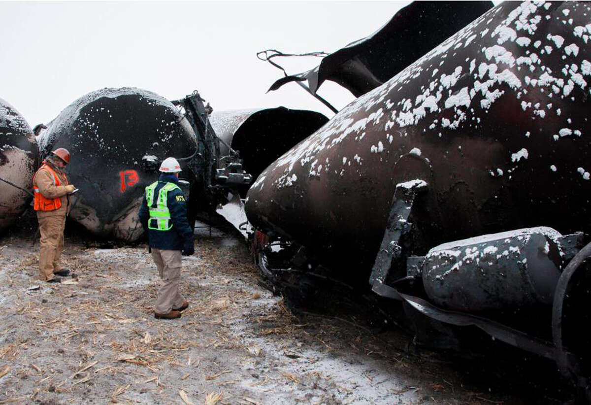 National Transportation Safety Board board member Robert Sumwalt, right, looks over damaged rail cars in Casselton, N.D., late last year after a derailment and fire.