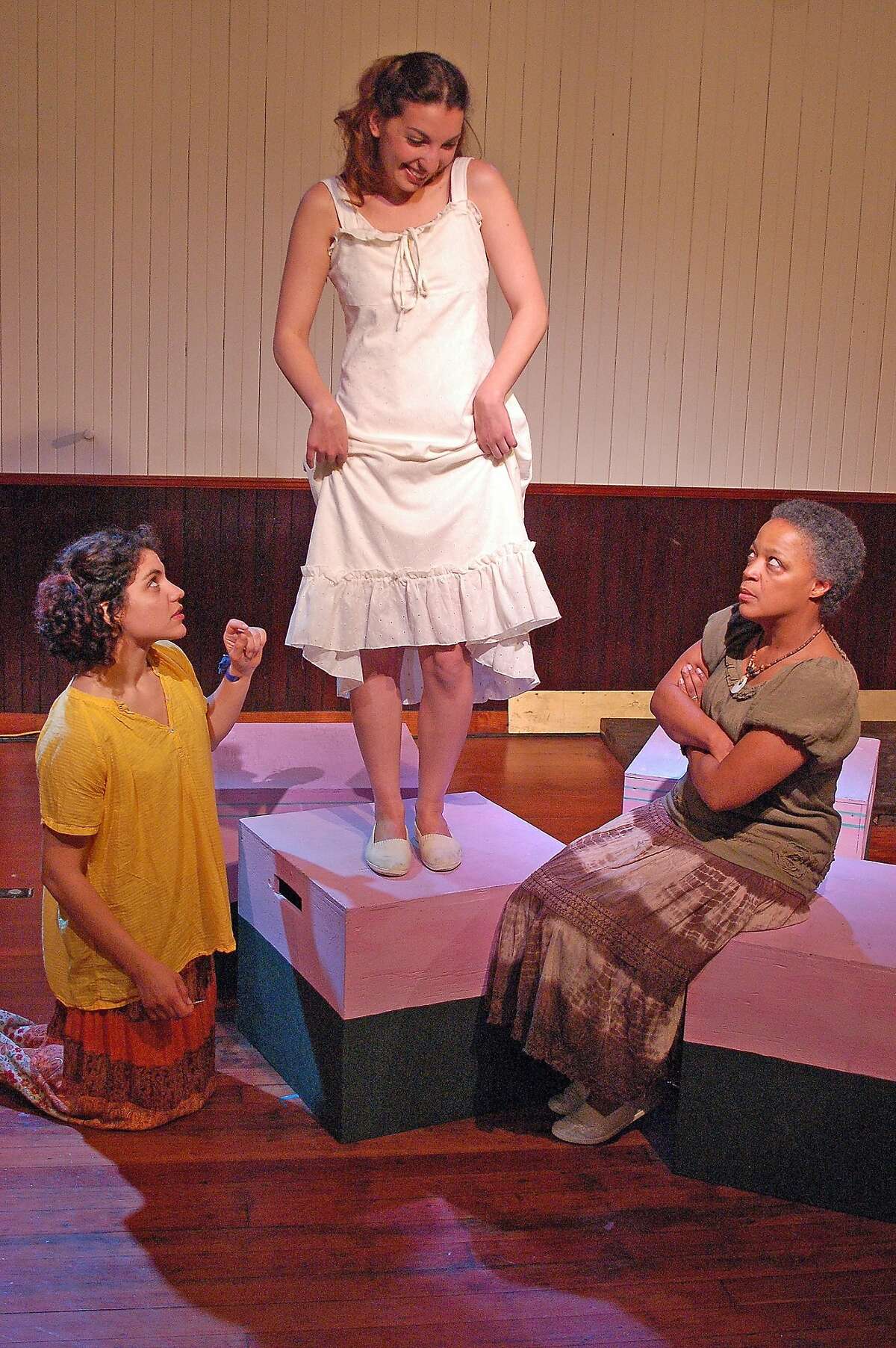 Senhora Costa (Cathleen Riddley, right) and daughter Helena (Carla Pauli, left) help prepare Belmira's (Livia Demarchi, center) wedding dress in Alter Theater's "The River Bride"