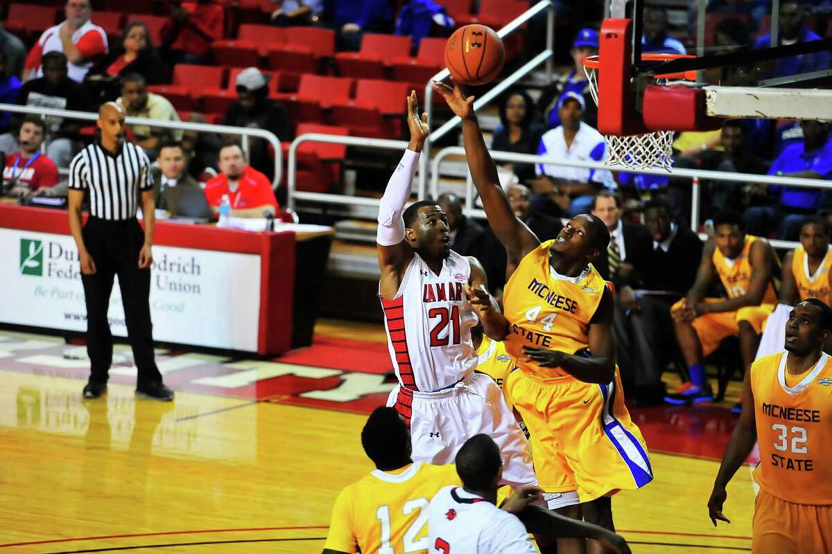 Lamar Cardinals Donovan Ross, No. 21, center, drives the ball in against McNeese State Cowboys Austin Lewis, No. 44, at the Montagne Center. Michael Rivera/@michaelrivera88 Photo taken Saturday, 01/11/14