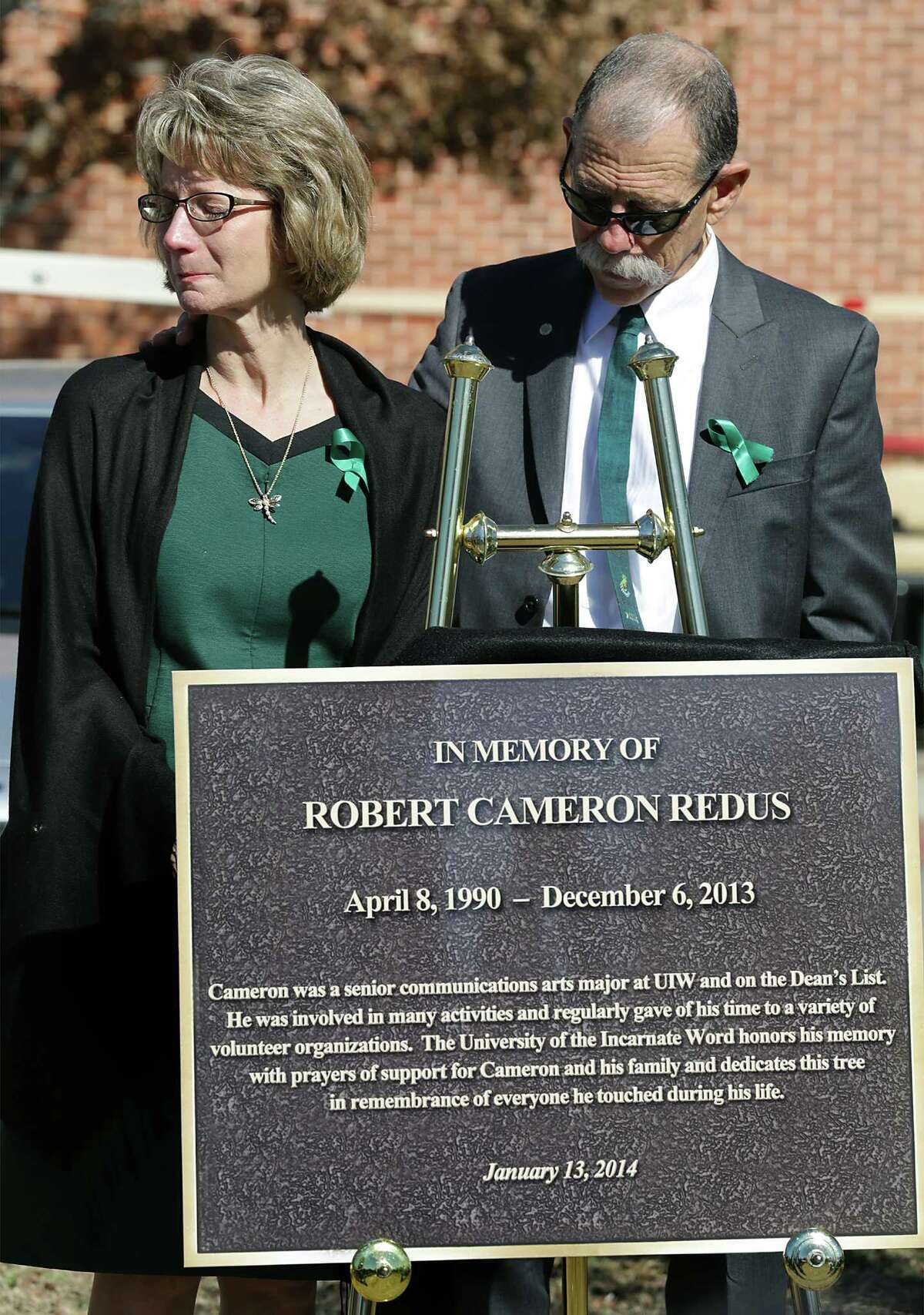 Mickey, right, and Valerie Redus, parents of Robert Cameron Redus, stand by a marker that is next to a tree planted in memory of the University of the Incarnate Word student that was fatally shot by a UIW officer. Monday, Jan. 13, 2013.