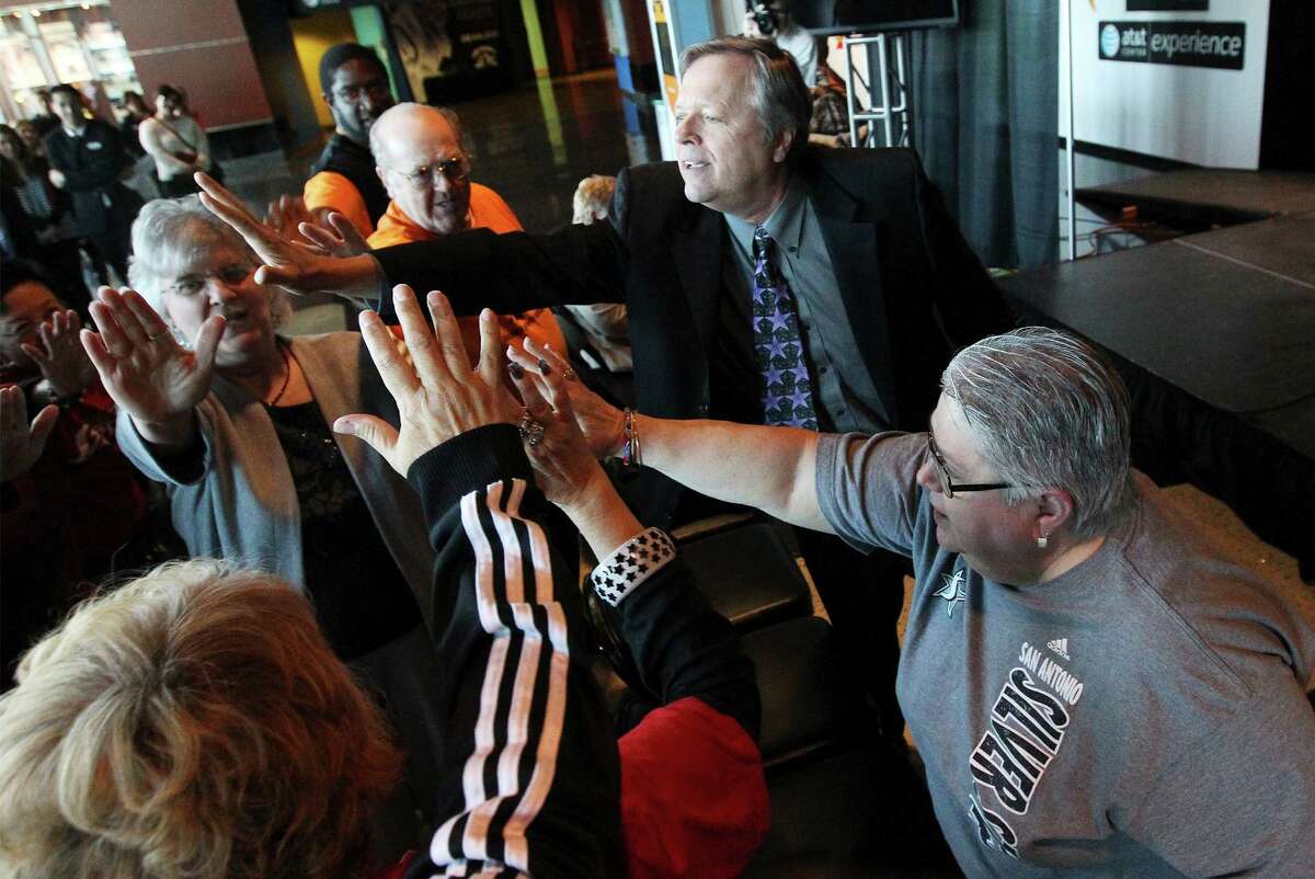 San Antonio Stars basketball head coach Dan Hughes gathers fans for a collective high-five during a presser to announce the team's name change - formerly the Silver Stars - and to show off their new logo at the AT&T Center on Tuesday, Jan. 14, 2014. The Stars also announced their first ever marquee sponsor, H-E-B.