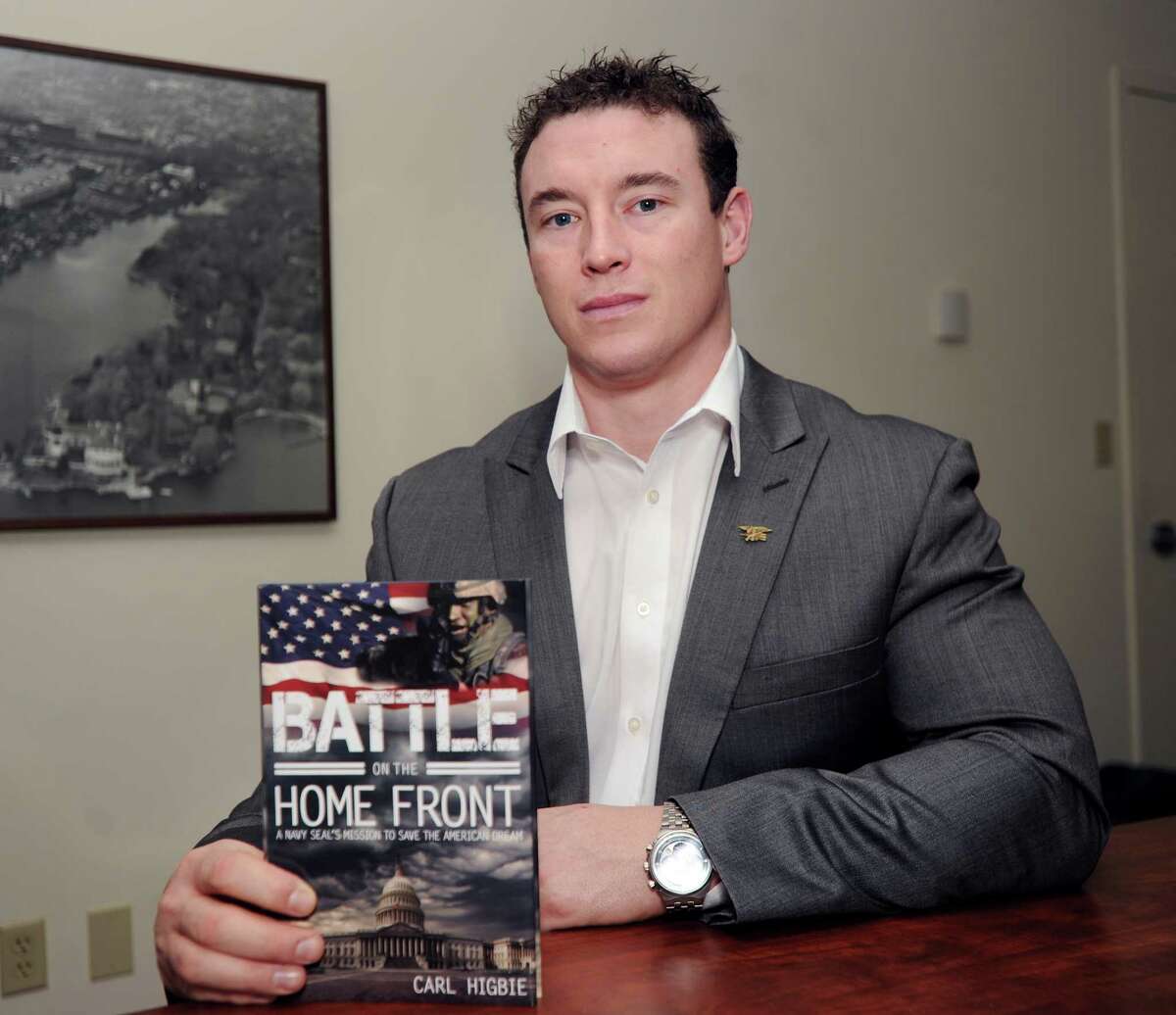 Holding his book "Battle on the Home Front," Carl Higbie, a former Navy SEAL who did two tours of duty in Iraq, at the office of the Greenwich Time, Greenwich, Conn., Tuesday, Jab. 14, 2014. Higbie, a Greenwich resident, is running for Congress in the 4th District as a Republican.