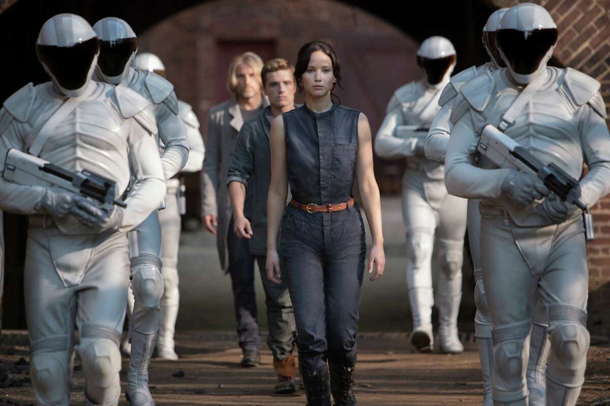 This image released by Lionsgate shows Jennifer Lawrence as Katniss Everdeen, from foreground to background, Josh Hutcherson as Peeta Mellark and Woody Harrelson as Haymitch Abernathy in a scene from "The Hunger Games: Catching Fire." (AP Photo/Lionsgate, Murray Close) ORG XMIT: NYET536