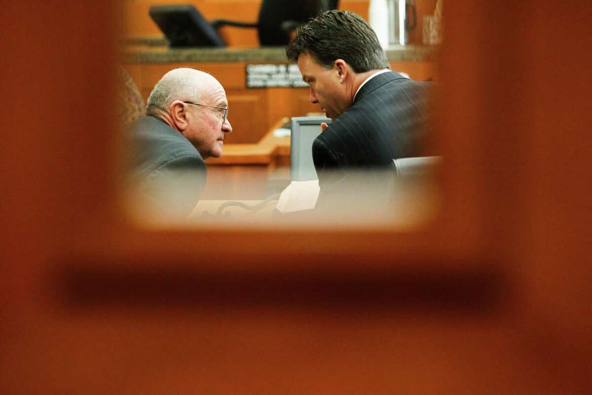 Dave Wilson, left, confers with his attorney during Wednesday's court hearing that ended with a ruling in his favor.