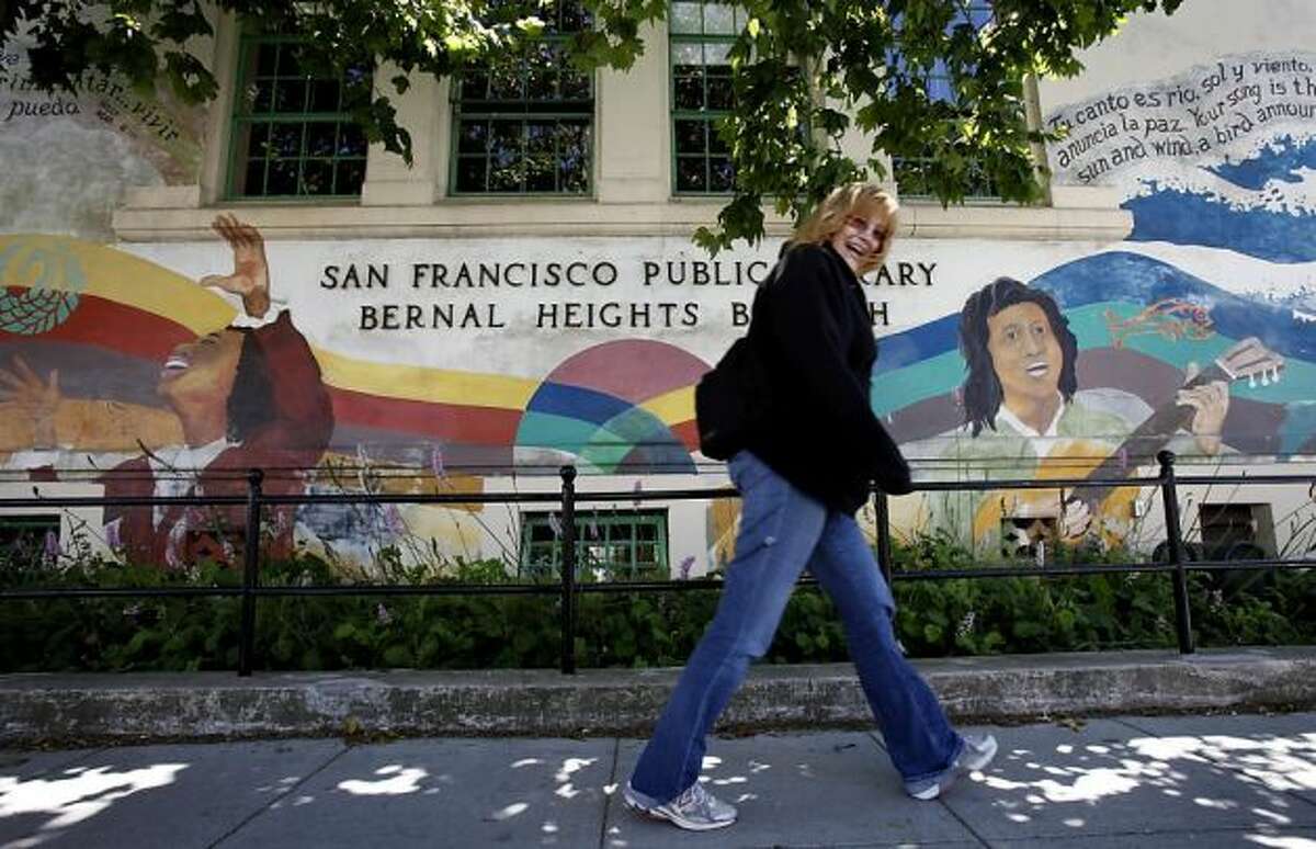 A woman walks past the front of the Bernal Heights Library. Photo: Brant Ward, The Chronicle