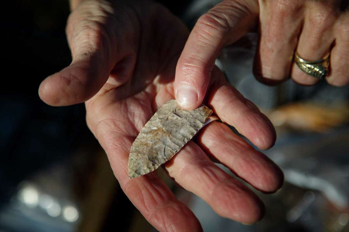 Linda Gorski holds an ancient Scottsbluff dart point found in the excavated dirt.