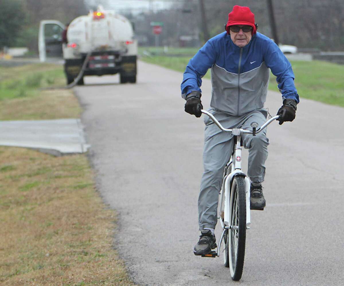 Cliff Howard rides a bicycle on Spence road as a cold front moves through the area Sunday, Jan. 5, 2014, in Houston. ( James Nielsen / Houston Chronicle )