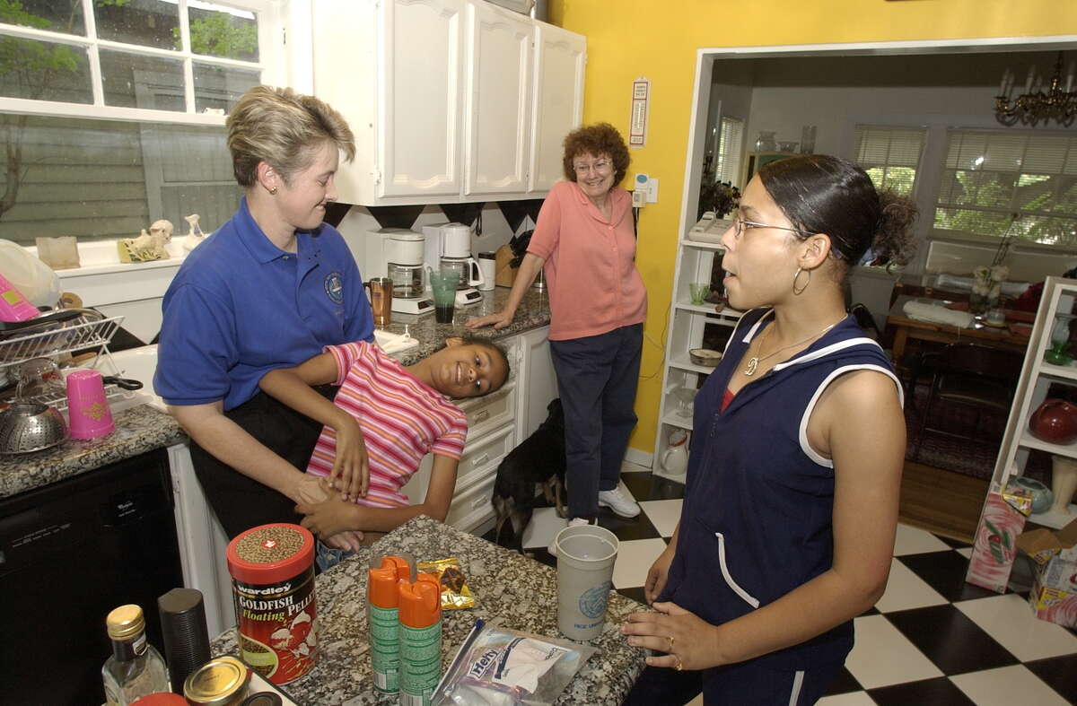 City Comptroller Anise Parker, far left, and her partner Kathy Hubbard were together for 12 1/2 years when they decided to adopt Marquitta, now 8. Marquitta's older sister Daniela, 13, joined the family a year ago this June. Planning for afternoon of shopping in Montrose home, Saturday, May 22, 2004. Chronicle/Ben DeSoto. HOUCHRON CAPTION (06/25/2004): City Controller Annise Parker, far left, and her partner Kathy Hubbard also faced an uphill battle when they adopted Marquitta, 9, and her older sister, Daniela, 13. Parker said the judge refused to let anyone in the court hear her case.