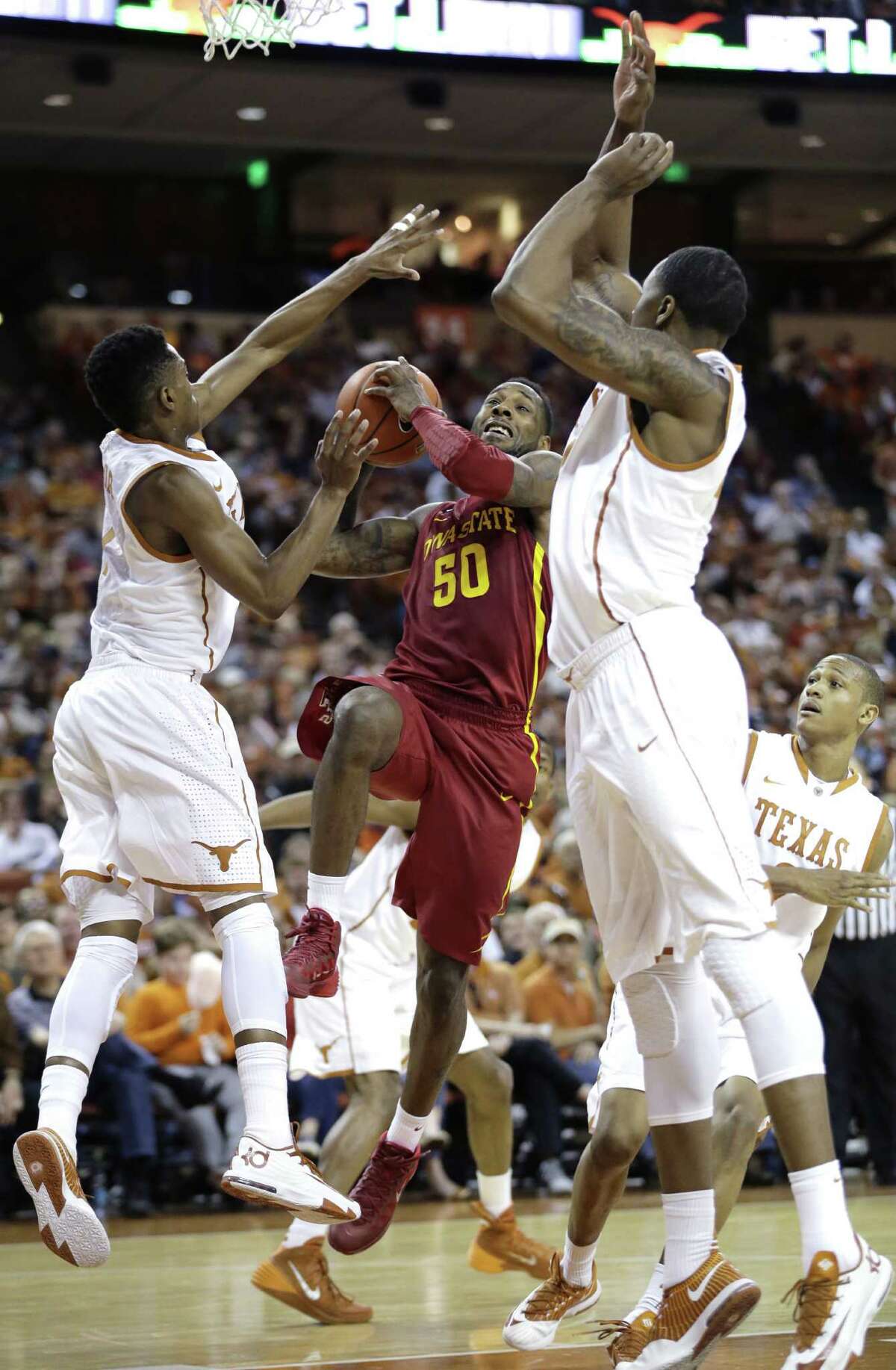 Iowa State's DeAndre Kane (50) drives to the basket between Texas defenders Isaiah Taylor, left, and Prince Ibeh, right, during the second half on an NCAA college basketball game, Saturday, Jan. 18, 2014, in Austin, Texas. Texas won 86-76. (AP Photo/Eric Gay)