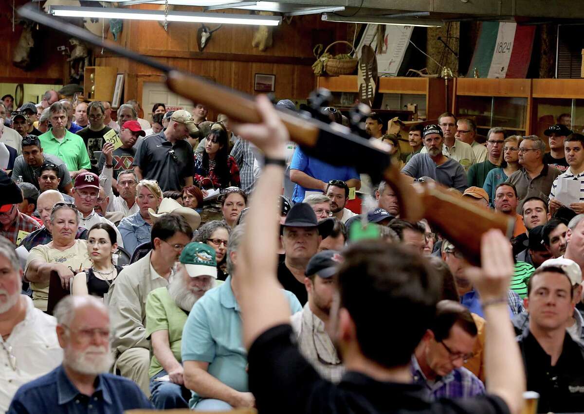 A bidder bids on a Browning 8500 shotgun at the auction January 19, 2014. Over 90 guns, ammunition, gun accessories, a BBQ trailer, a police motorcycle, coins, animals skins and taxidermy of Dr. Michael G. Brown items were auctioned at the Webster's Auction Palace in Houston, Texas.