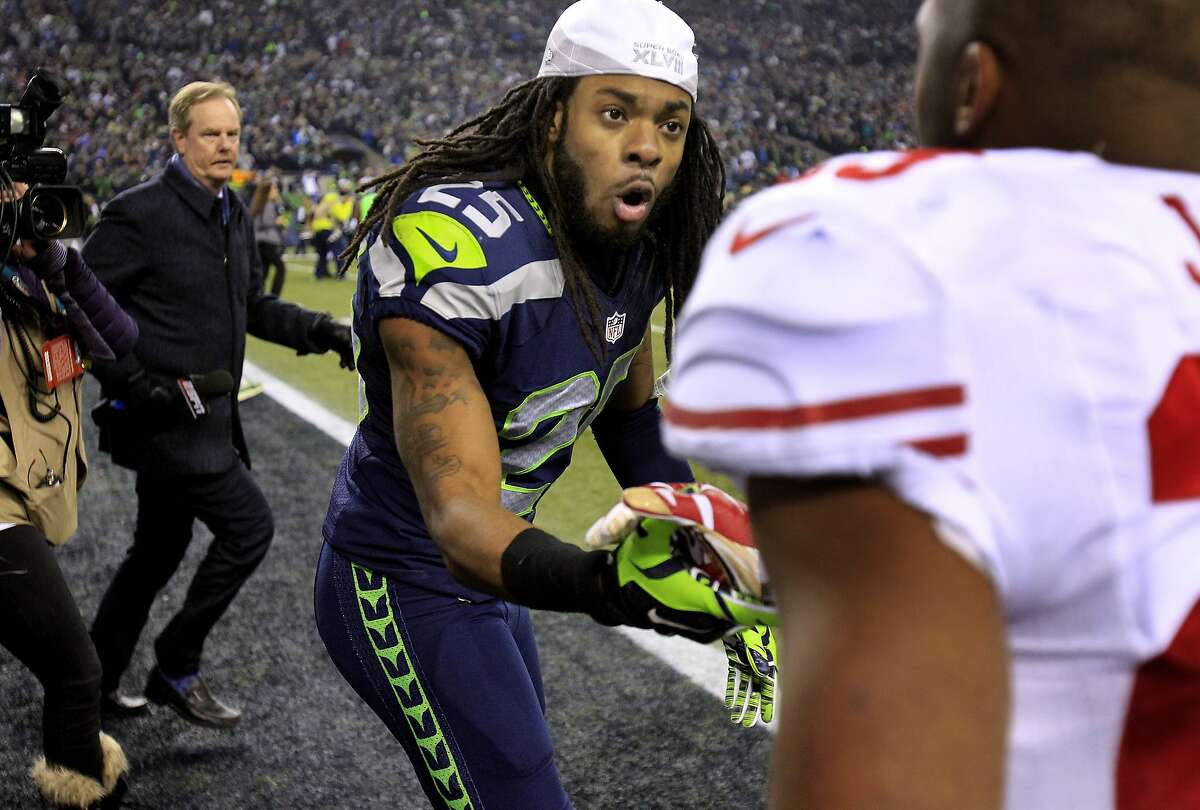 Richard Sherman (25) of the Seahawks greeted LaMichael James, who was injured earlier in the game. The Seattle Seahawks defeated the San Francisco 49ers 23-17 to win the NFC championship and a trip to the Super Bowl at CenturyLink Field in Seattle, Washington.
