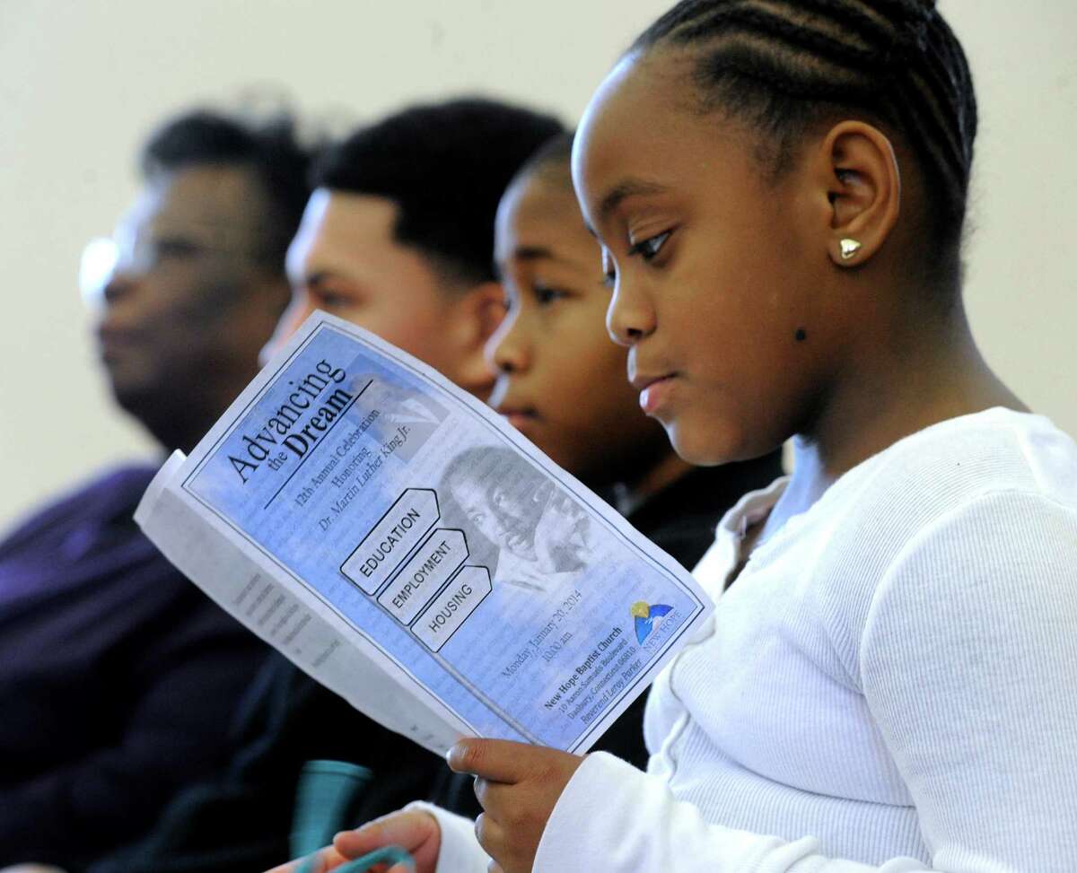 Ki'Arie Moorer, 8, of Danbury, Conn. looks at a program during New Hope Baptist Church's 12th annual celebration honoring Dr. Martin Luther King Jr., Monday, January 20, 2014.