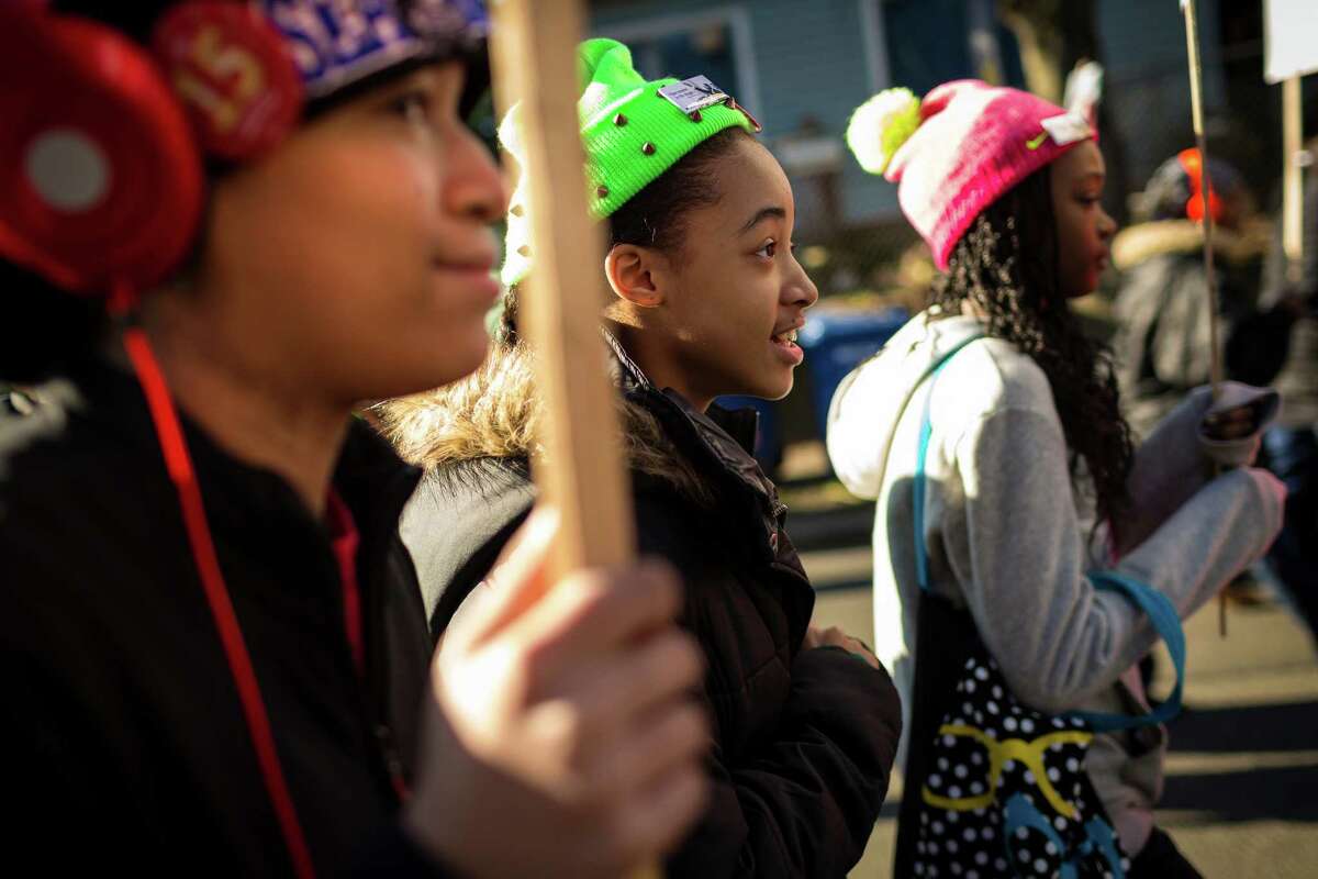 Supporters flocked together, hoisting signs and breaking into song during the 32nd ?’Rise Up! Restore the Dream!?“ annual celebration for Martin Luther King, Jr., on Monday, Jan. 20, 2014, in Seattle. A mass of hundreds walked from Garfield High School to Westlake Park. The event also included a rally and a workshop.