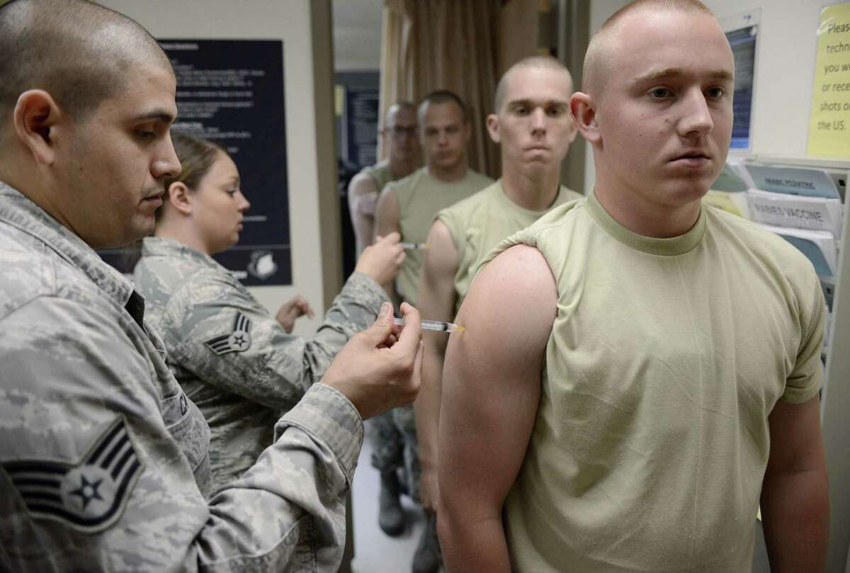 Staff Sgt. Stephen Carreon administers the rabies vaccine to Airman Kevin Danaher at Wilford Hall Ambulatory Surgical Center.