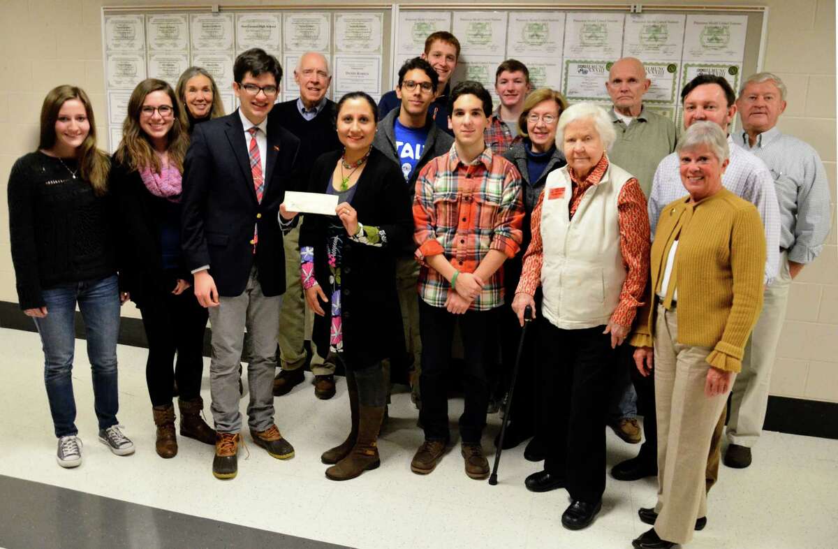 Shekaiba Wakili-Bennett, co-chair of the United Nations Committee of New Canaan, holds a $1,000 check the organization donated to the New Canaan High School Model U.N. Club on Friday, Jan. 10, at the high school in New Canaan, Conn. Members of the committee and the club, pictured above, came to the school to learn about the students' upcoming trip to The Hague International Model U.N. conference.