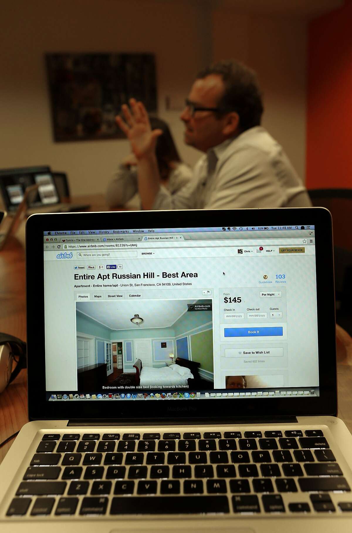 A listing for a unit in Chris Butler's former apartment building is shown on the website of AirBnB as Butler speaks with colleagues as his place of work, on Tuesday Jan. 21, 2014. Butler is Chief Operating Officer of Tumlis, a real estate for sale start up company in San Francisco, Calif. He was evicted from his Union Street apartment where he had lived for the past ten years and now his landlord is now renting it out on AirBnB.