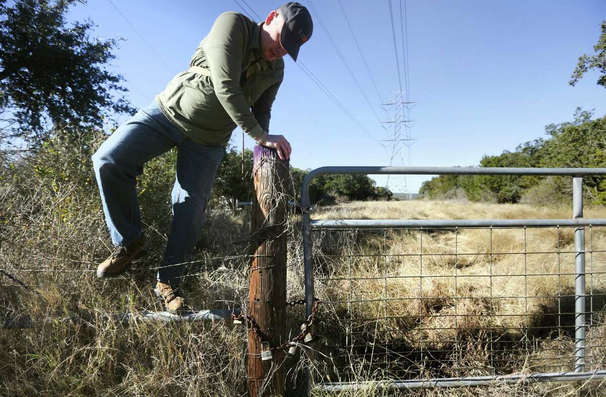 Troy Breeden, a volunteer searcher, climbs over a fence along a power line to look for Leanne Bearden. Forty four volunteers searched an area in Garden Ridge close to where Leanne Bearden was last seen. She has been missing since Jan. 17. Forty four volunteers signed up at Covenant Baptist Church for the search organized by friends and family members. Wednesday, Jan. 22, 2014.