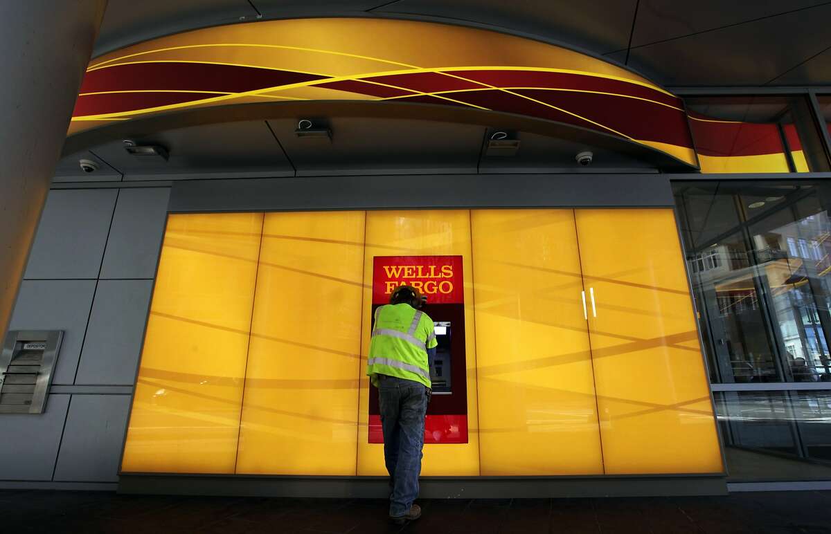 FILE - In this Jan. 17, 2012, file photo, a customer uses an ATM outside a Wells Fargo branch in Charlotte, N.C. Wella Fargo & Co. reports quarterly results before the market opens on Tuesday, Jan. 14, 2014. (AP Photo/Chuck Burton, File)