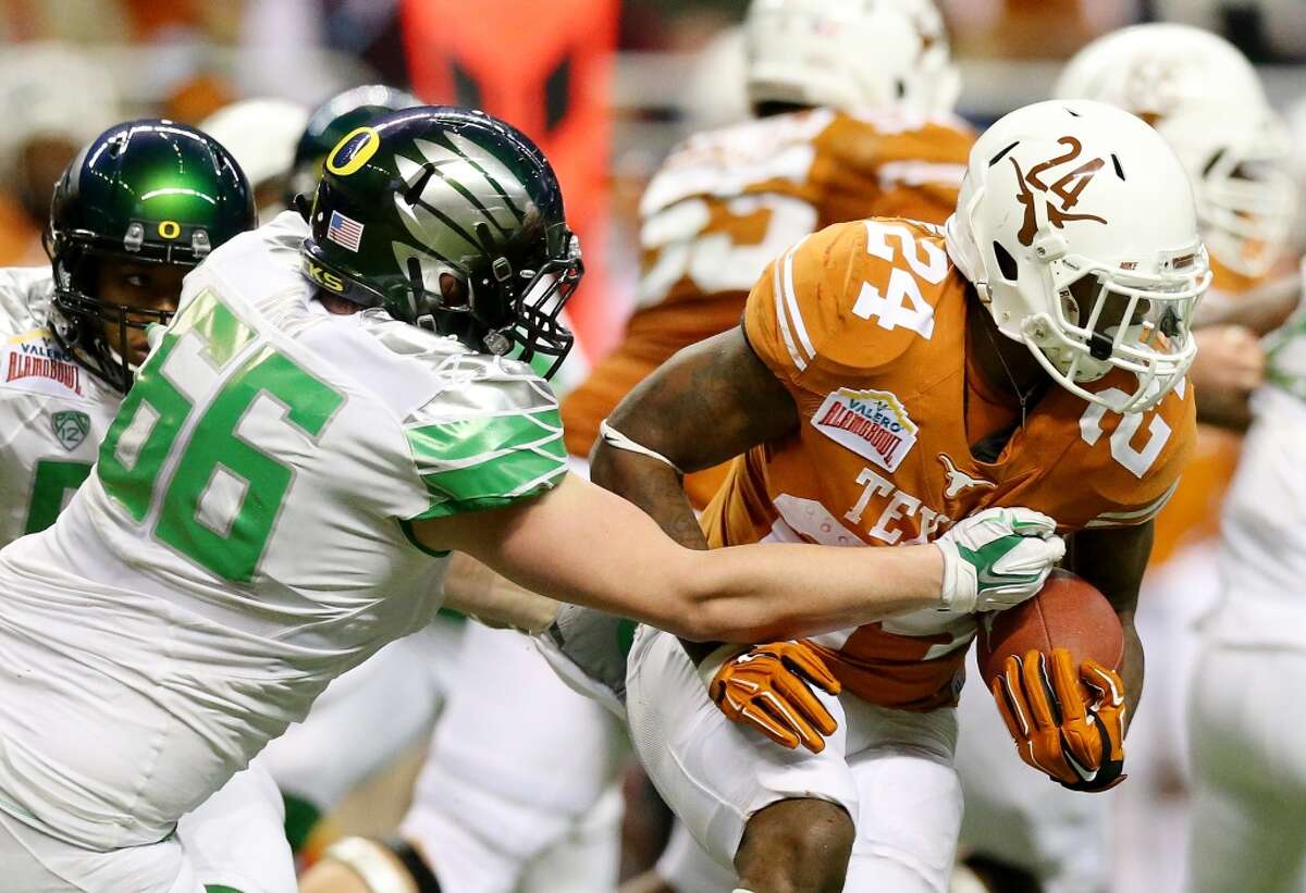 Running back Joe Bergeron #24 of the Longhorns carries the ball as defensive tackle Taylor Hart #66 of the Ducks defends.
