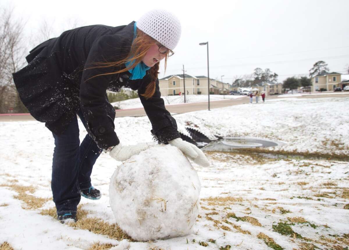 Christina Rizer, a Sam Houston State University senior from Spring, rolls a ball of snow to make a snowman following an overnight snowfall Friday, Jan. 24, 2014, in Huntsville. Classes at SHSU were cancelled Friday. ( Brett Coomer / Houston Chronicle )