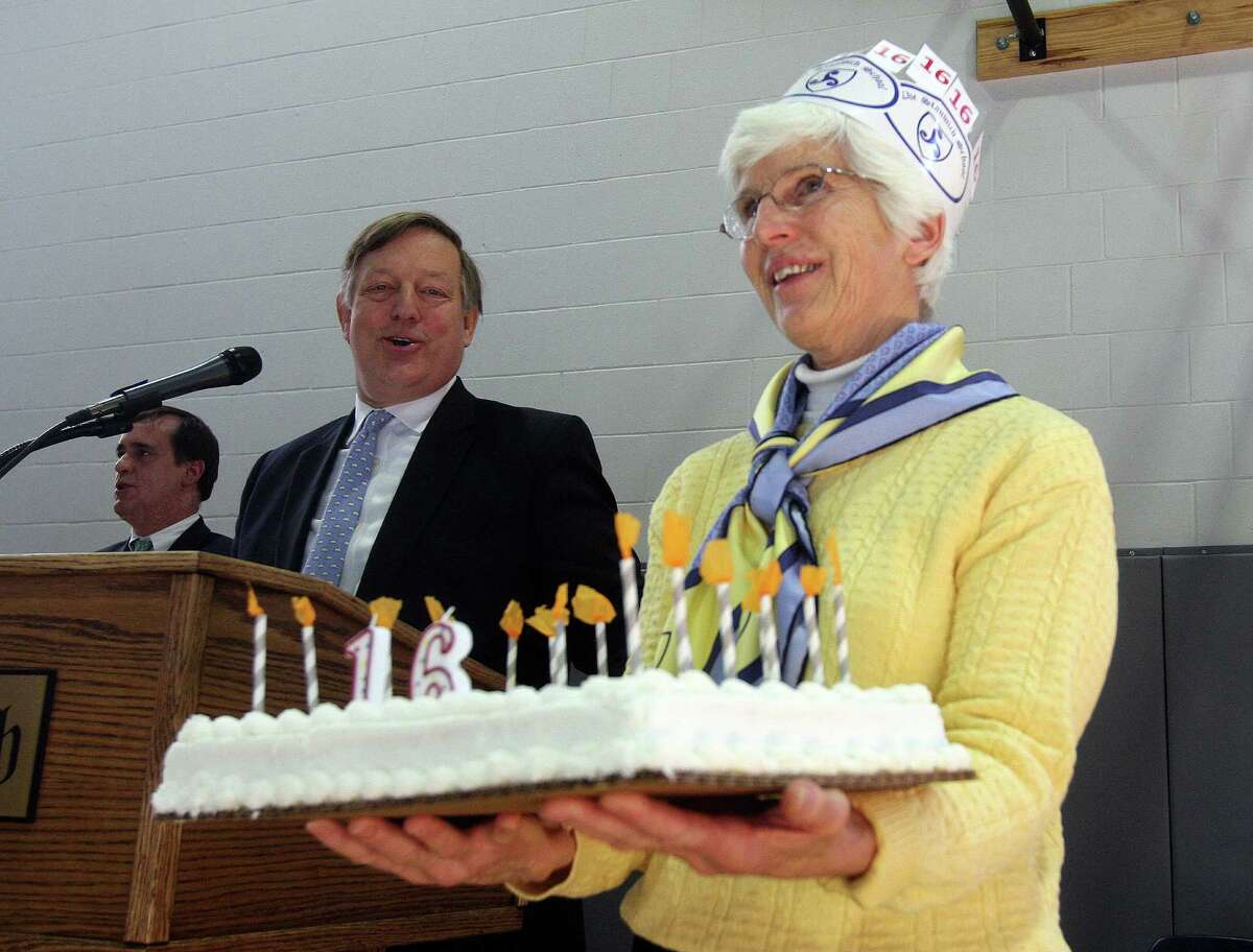 Barrie Richmond of the Stanwich School shows off a birthday cake to students and teachers at an assembly to mark its 16th anniversary as a school on Friday, Jan. 24, 2014, in Greenwich, Conn. Joining in the celebration is Paul Geise, Head of School.